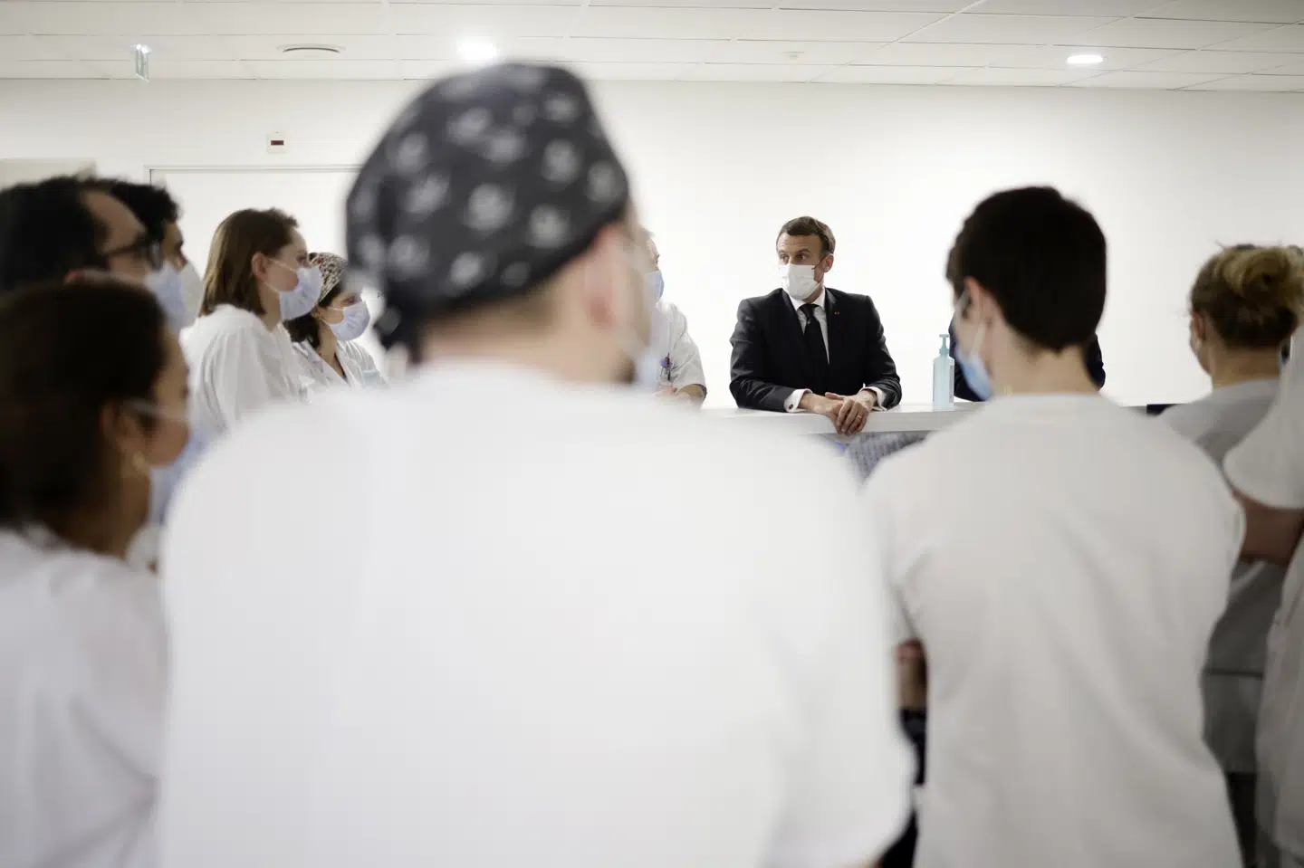 Præsident Emmanuel Macron, i centrum af billedet, taler med personale på intensivafdeling nær Paris. Frankrig har ingen grund til at afvise covid-19-vacccinen fra AstraZeneca/Oxford Universitet, siger regeringstalsmand Gabriel Attal fredag. Yoan Valat/Ritzau Scanpix