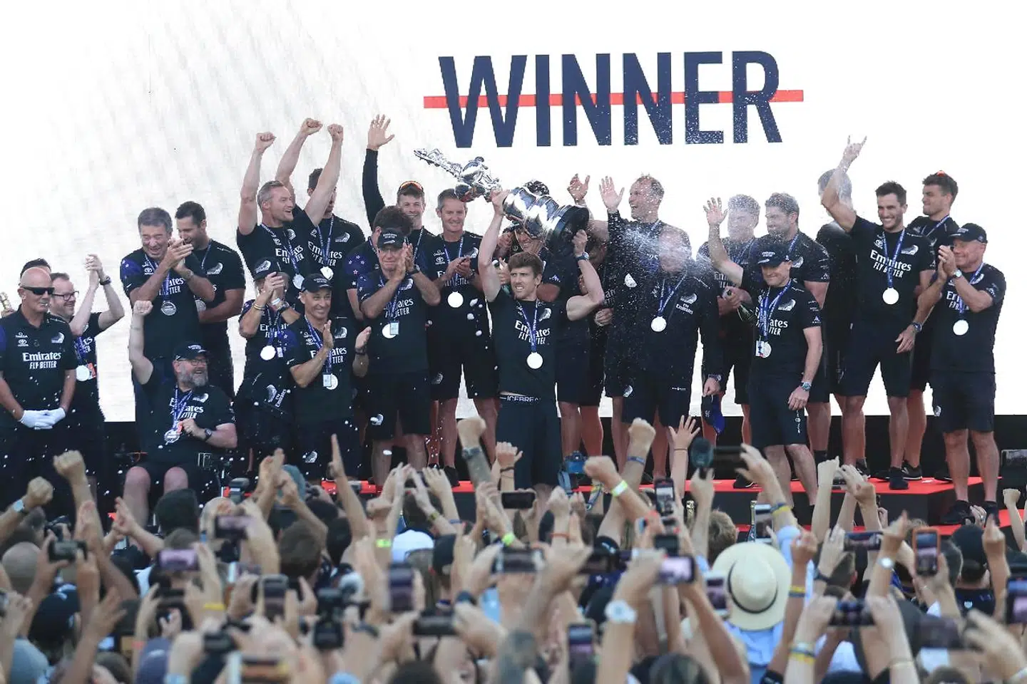 TOPSHOT - Team New Zealand's skipper Peter Burling (C) holds the America's Cup, affectionately known as the Auld Mug, after winning the 36th America's Cup against Luna Rossa Prada in Auckland on March 17, 2021. (Photo by Gilles Martin-Raget / AFP)