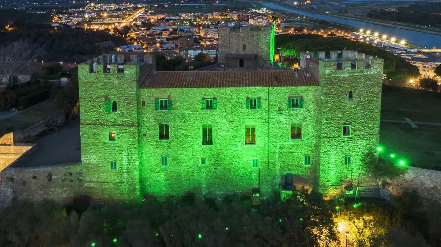 Slottet Castiglione della Pescaia oplyst i grøn.