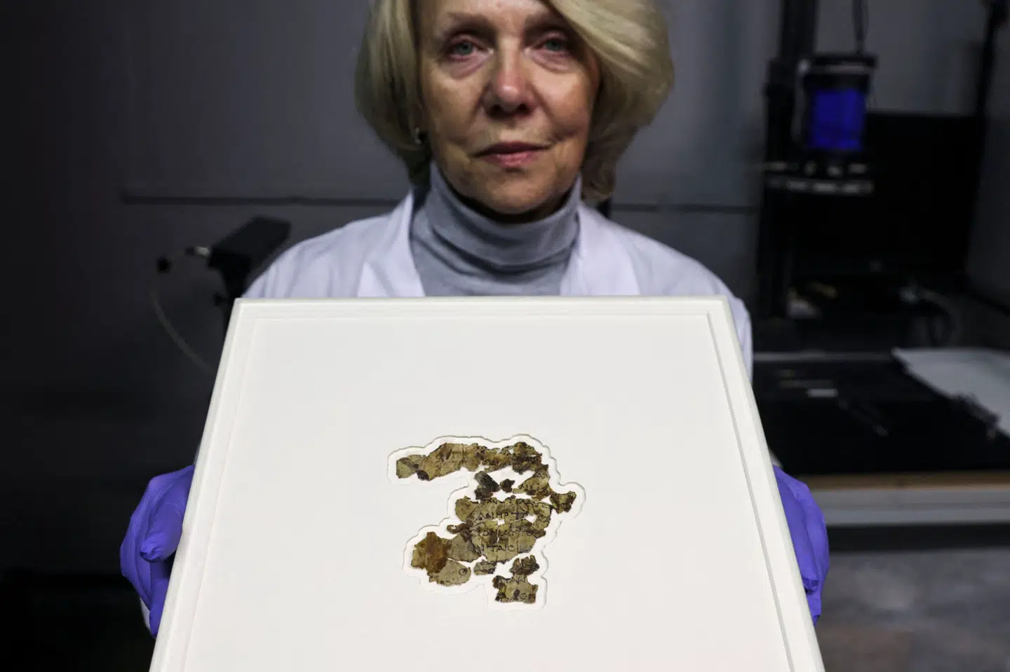 Den israelske konservator Tanya Bitler fremviser fragmenter fra dele af en bibelsk skriftrulle, som er 2000 år gammel, og som omtales som et af de mest betydelige fund siden Dødehavsrullerne. Menahem Kahana/Ritzau Scanpix