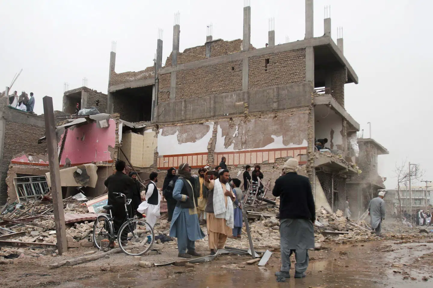 Lokale indbyggere inspicerer ødelæggelserne, efter en bilbombe i Herat i det vestlige Afghanistan lørdag. Mindst otte blev dræbt og omkring 50 blev såret af en bombe. Jalil Ahmad/Reuters