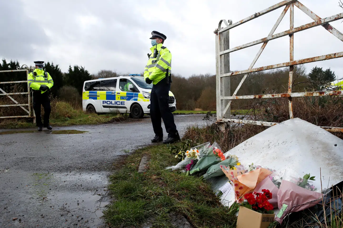 Politiet holder vagt ved indkørslen til Great Chart Golf & Leisure Country Club i Ashford, hvor folk har lagt blomster og en sidste hilsen til den dræbte Sarah Everard. Det var i dette område, at et lig blev fundet onsdag. Fredag bekræfter politiet, at der er tale om den 33-årige kvinde. Paul Childs/Reuters