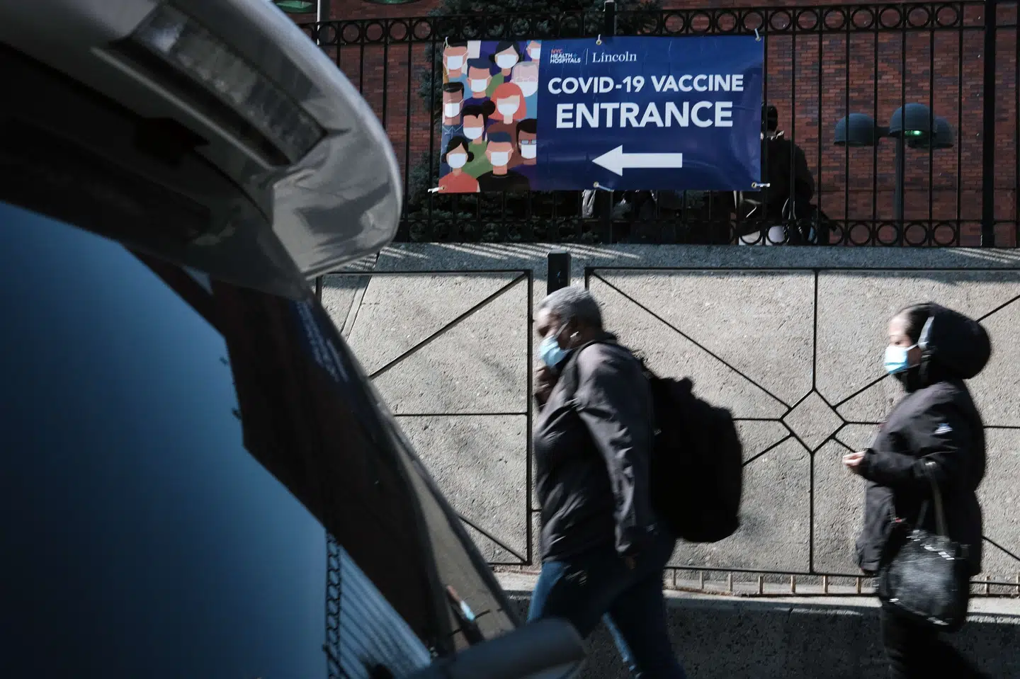 Folk passerer forbi et vaccinationscenter i Bronx i New York, der sidste år var hårdt ramt af coronapandemien. Den store hjælpepakke, der fredag ventes underskrevet af præsident Joe Biden, er med til at holde hånden under de mange amerikanere, der har mistet jobbet i løbet af coronakrisen. Spencer Platt/Ritzau Scanpix