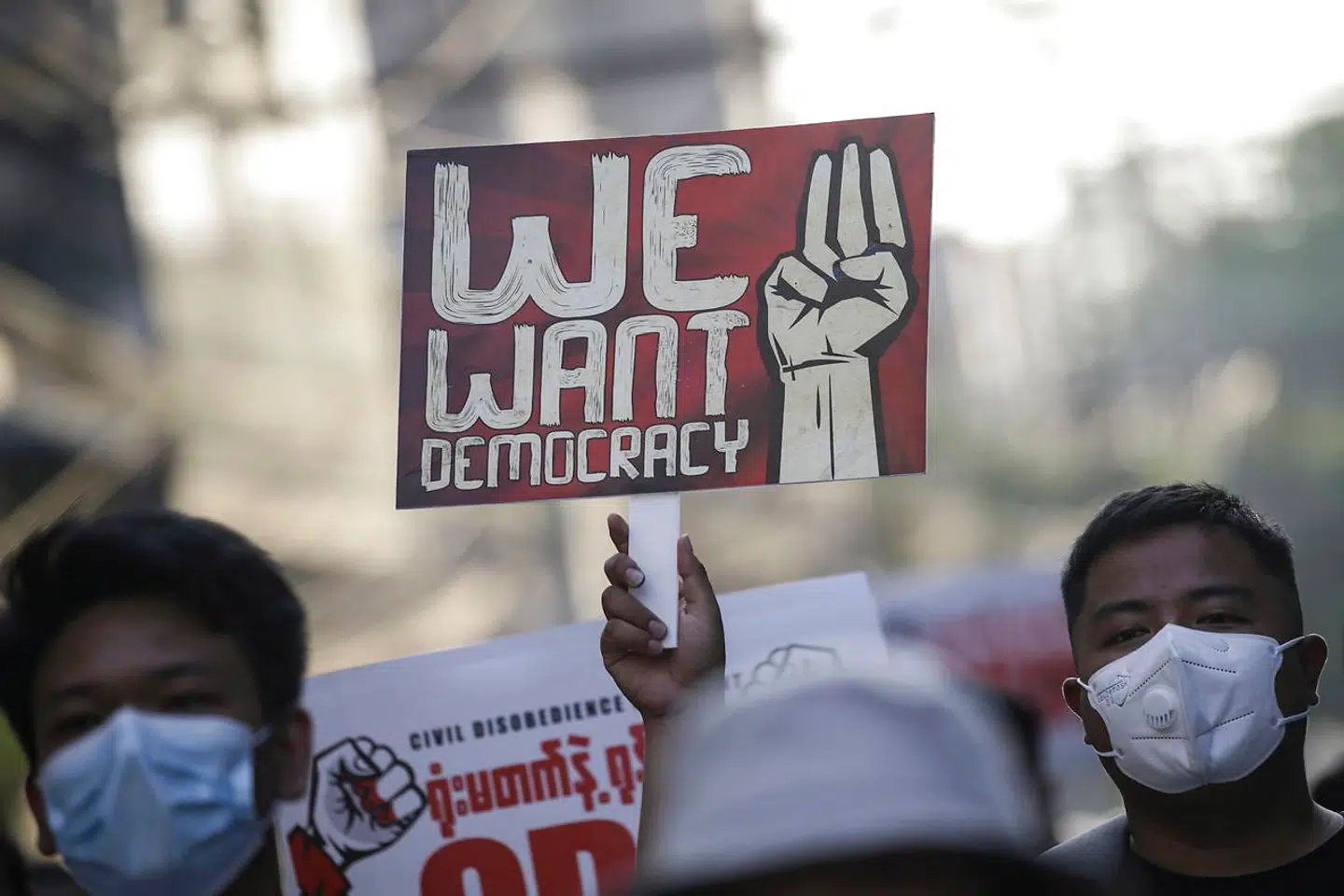 En demonstrant holder en plakat op med teksten 'Vi vil have demokrati' på gaden i Yangon 10. marts.