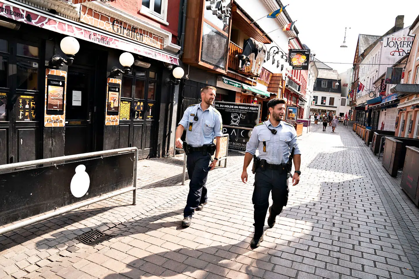 Politi på patrulje i forlystelsesgaden Jomfru Anegade i Aalborg, tirsdag den 11. august 2020. Nordjyllands Politi gør med virkning fra tirsdag den 11. august 2020 kl. 14:00 en stor del af Aalborgs nærliggende og populære havnefront til et hotspot. Et klart signal til borgerne om at huske at holde afstand for at reducere risikoen for coronasmitte.. (Foto: Henning Bagger/Ritzau Scanpix)