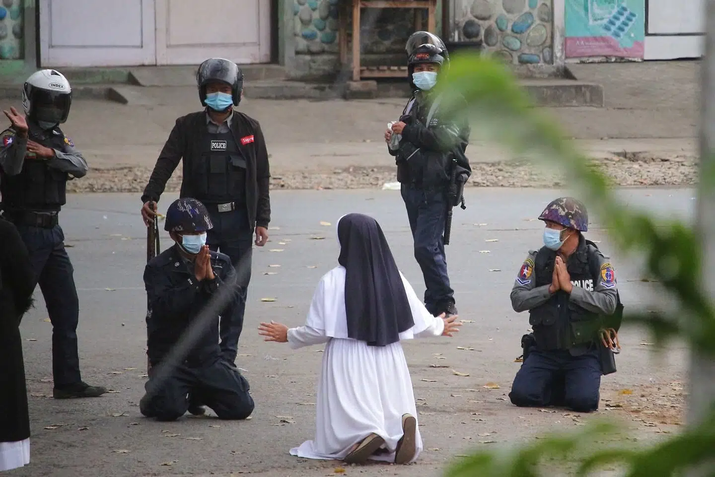 This handout photo taken on March 8, 2021 and released on March 9 by the Myitkyina News Journal shows a nun pleading with police not to harm protesters in Myitkyina in Myanmar's Kachin state, amid a crackdown on demonstrations against the military coup. (Photo by Handout / Myitkyina News Journal / AFP) / RESTRICTED TO EDITORIAL USE - MANDATORY CREDIT "AFP PHOTO / Myitkyina News Journal " - NO MARKETING - NO ADVERTISING CAMPAIGNS - DISTRIBUTED AS A SERVICE TO CLIENTS