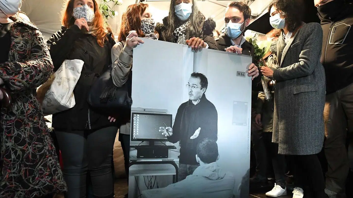 Samuel Patys kolleger og pårørende holder et billede af ham under en mindehøjtidelighed i oktober 2020. Nu viser det sig, at den fortælling, der startede kædereaktionen, der første op til hans død, bygger på en løgn. (Arkivfoto)