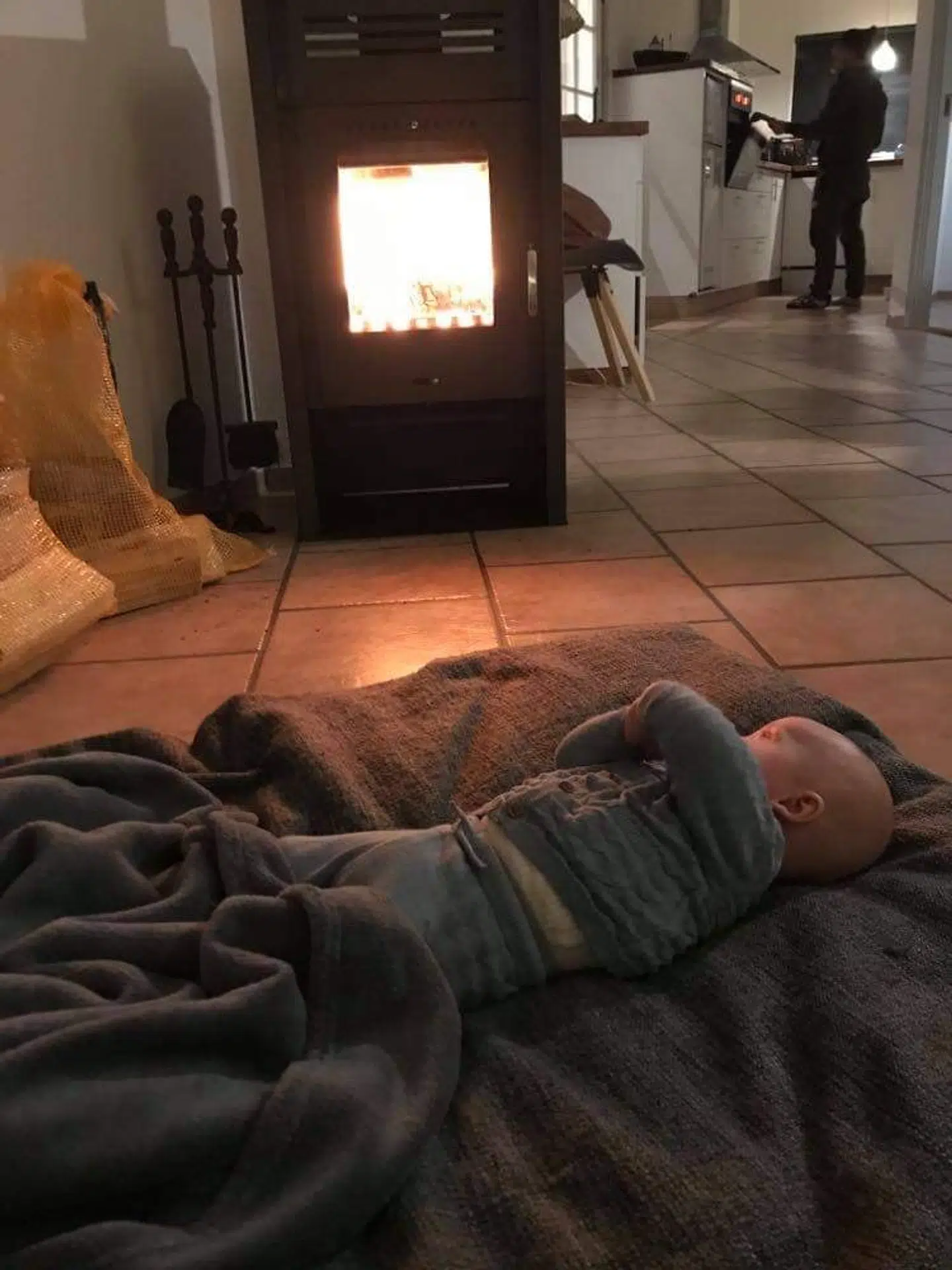 Mathias og Stines baby ligger foran brændeovnen. Det eneste sted, hvor der var bare nogenlunde varmt i sommerhuset.