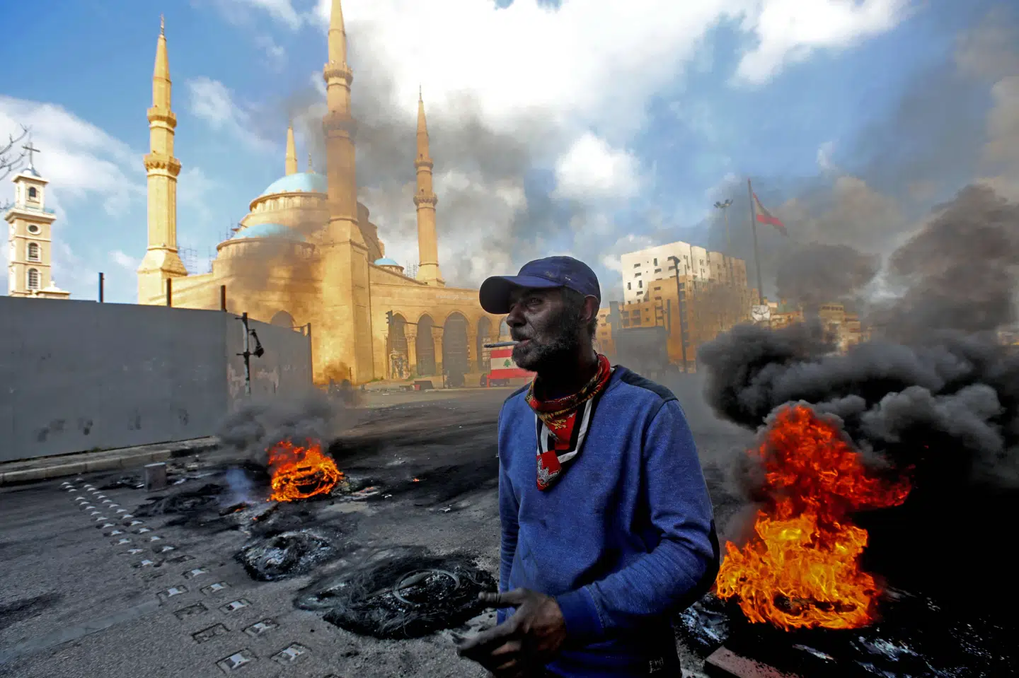 Demonstranter satte ild til bildæk i det centrale Beirut mandag, hvor der igen var protester mod regeringen. Demonstranterne advarer landets politikere om, at en social eksplosion er på vej. Anwar Amro/Ritzau Scanpix