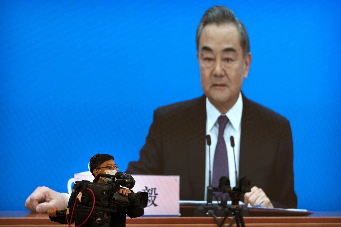 Kinas udenrigsminister Wang Yi på storskærmen under søndagens pressekonference. Mark Schiefelbein/Ritzau Scanpix