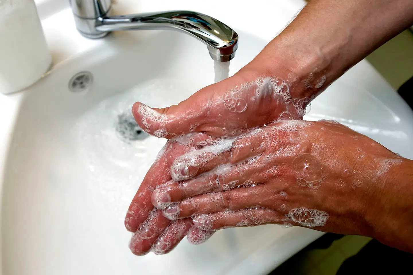 Vaske hænder med flydende håndsæbe.