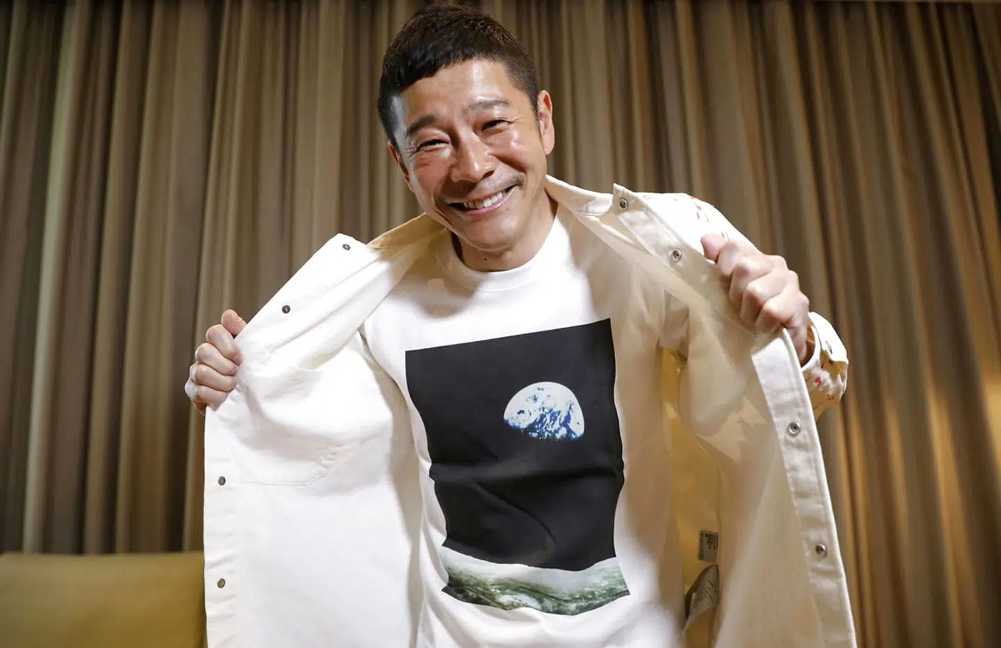 Japanese billionaire Yusaku Maezawa poses with his T-shirt bearing an image of Earth during an interview with Reuters in Tokyo, Japan, March 3, 2021. REUTERS/Kim Kyung-Hoon TPX IMAGES OF THE DAY