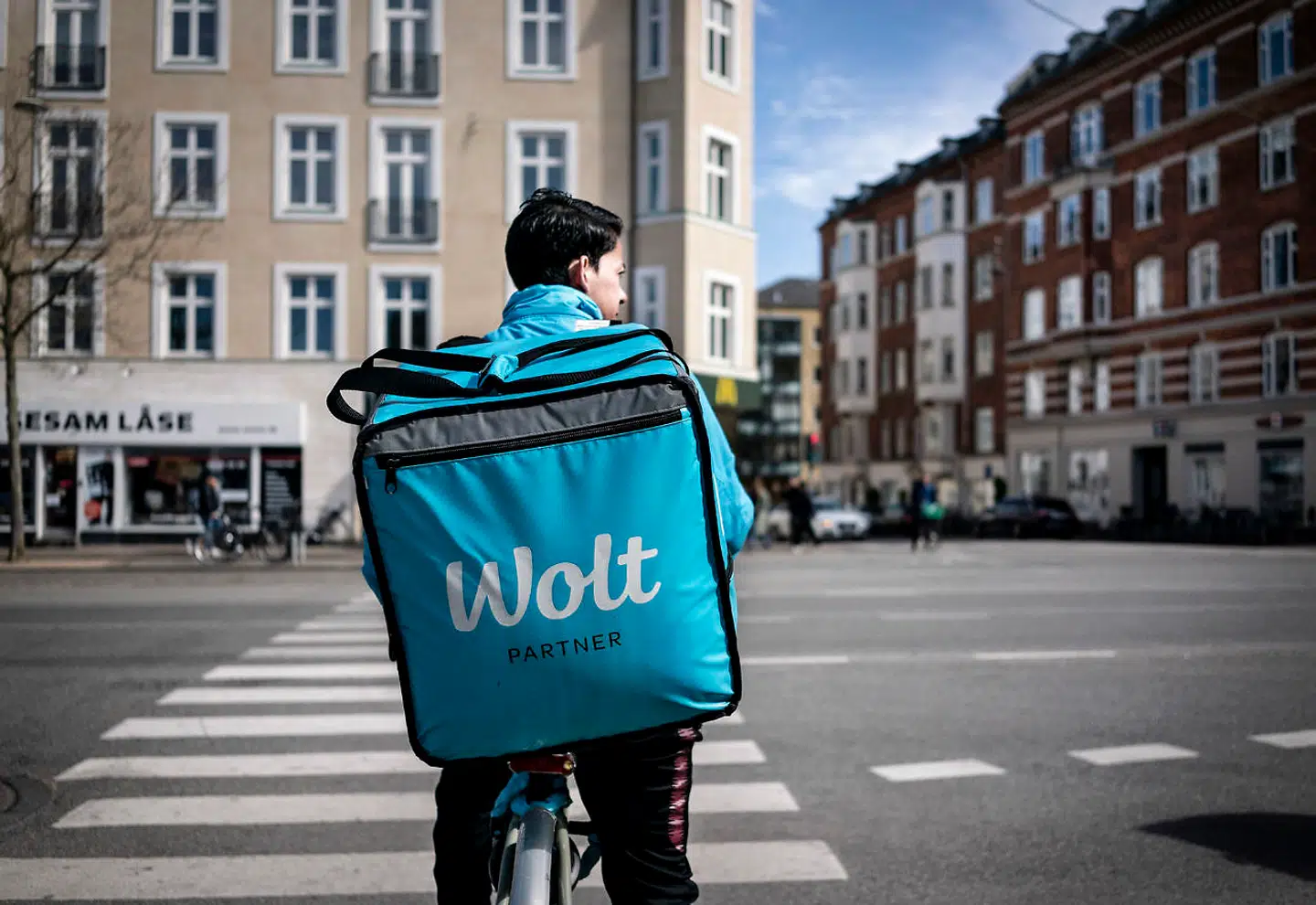 Covid-19: Reportage fra Østerbro i København, lørdag den 18. april 2020. Livet vender langsomt tilbage til normalen, folk går i butikker og nyder solen langs Søerne og i Fælledparken. Cykelbud fra Wolt på Østerbrogade. (Foto: Liselotte Sabroe/Ritzau Scanpix)