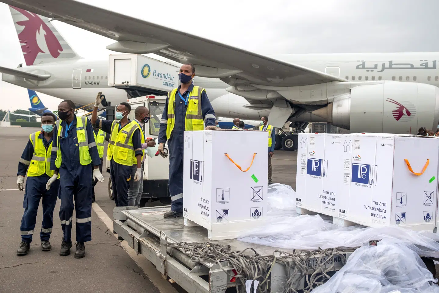 Toldere og sundhedsarbejdere står ved de første leveringer af covid-19 vaccine i Kigali i Rwanda onadag. Vaccineleveringerne er et led i det globale Covax-samarbejde, som blev sat i værk for at sikre vaccinationsprogrammer i verdens udviklingslande. Jean Bizimana/Reuters