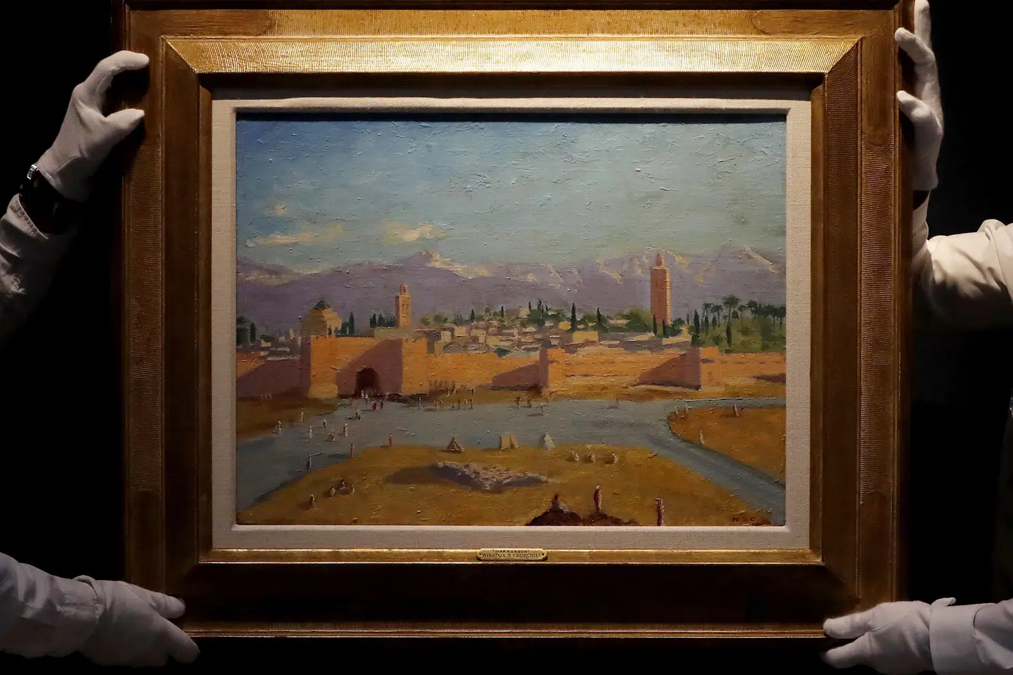 Ansatte ved auktionshuset Christie's fremviser oliemaleriet, som Winston Churchill lavede under et besøg i Marokko i 1943. Motivet er Koutoubia-moskeen i Marrakesh ved solnedgang. Frank Augstein/Ritzau Scanpix