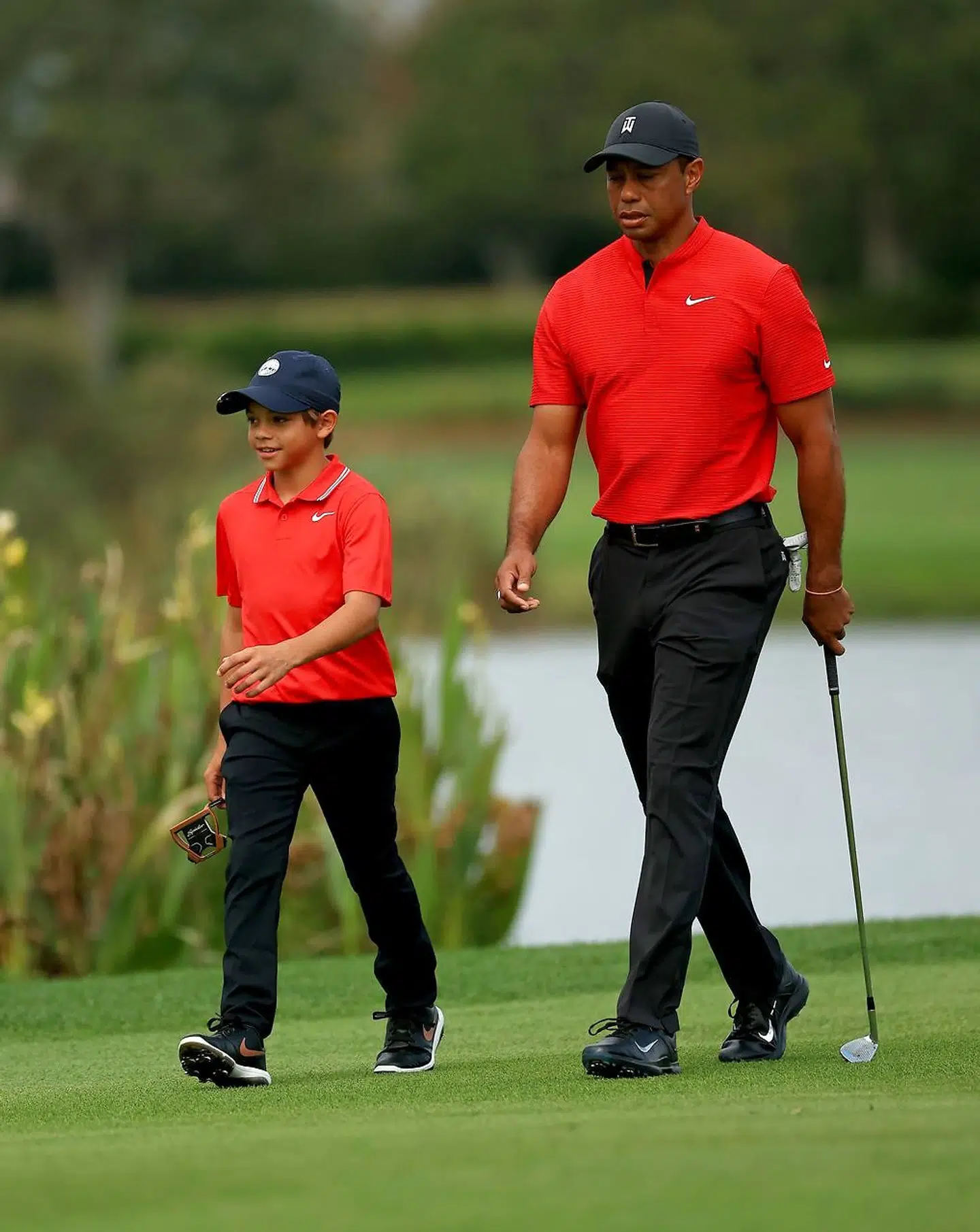 ORLANDO, FLORIDA - DECEMBER 20: Tiger Woods of the United States and son Charlie Woods walk up the 14th hole during the final round of the PNC Championship at the Ritz Carlton Golf Club on December 20, 2020 in Orlando, Florida. Mike Ehrmann/Getty Images/AFP == FOR NEWSPAPERS, INTERNET, TELCOS & TELEVISION USE ONLY ==
