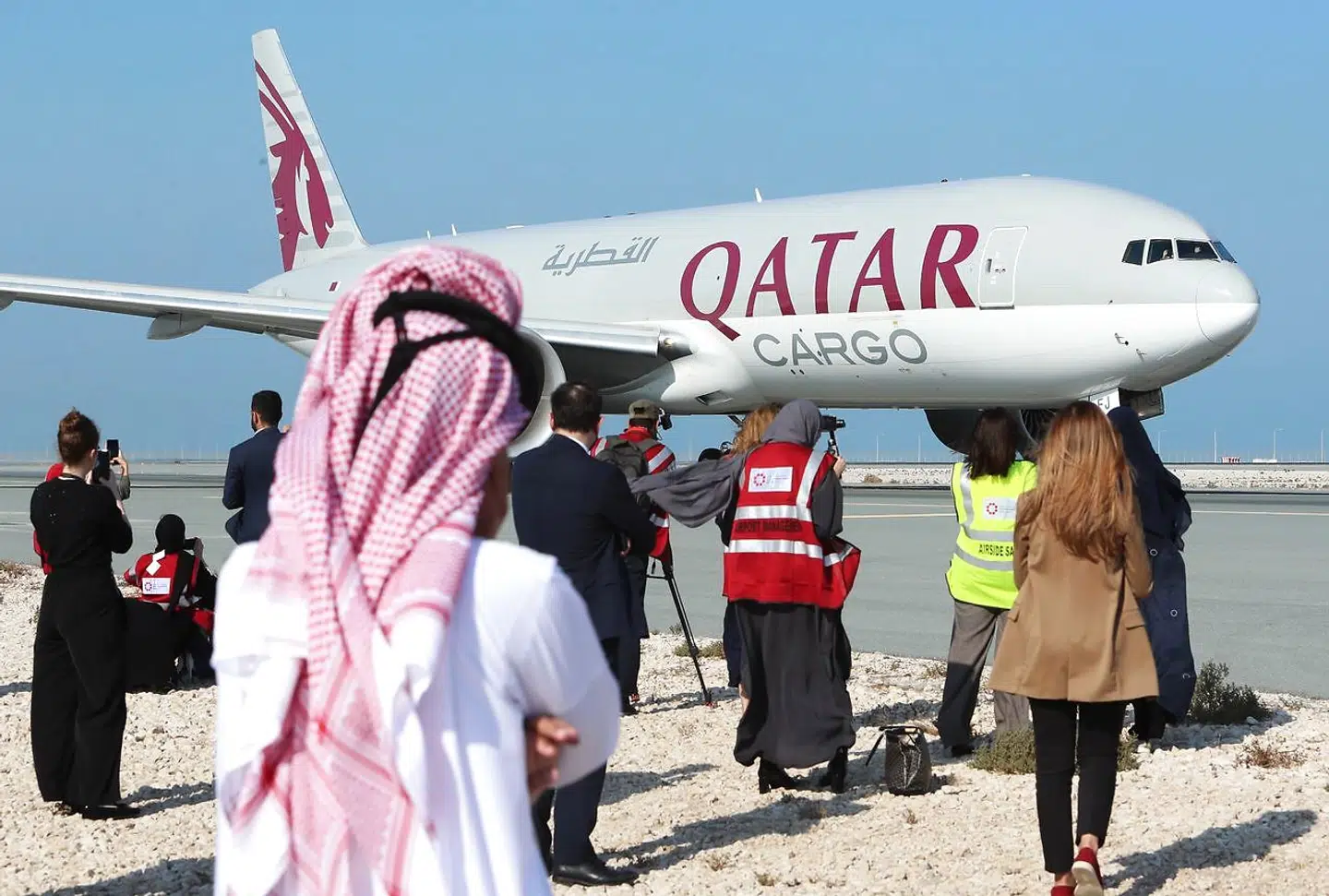 Journalister står i nærheden af Qatar Airways fly på landingsbanen i Hamad International Airport nær Qatars hovedstad Doha. Flyet skal, efter 3½ års pause, igen flyve til Saudi-Arabien.