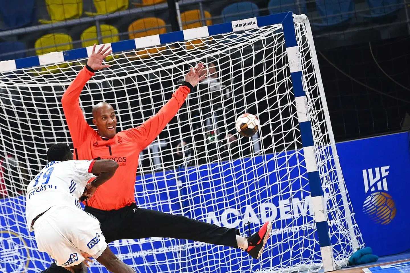 Portugal's goalkeeper Alfredo Quintana (back) fails to stop a ball during the 2021 World Men's Handball Championship match between Group III teams Portugal and France at the 6th of October Sports Hall in 6th of October city, a suburb of the Egyptian capital Cairo on January 24, 2021. (Photo by Anne-Christine POUJOULAT / POOL / AFP)