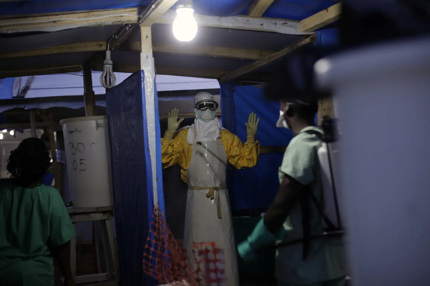 I dette billede fra et ebolaudbrud i Guinea i 2014 bliver en sundhedsarbejder desinficeret efter en vagt på et behandlingscenter for smittede. (Arkivfoto) Jerome Delay/Ritzau Scanpix