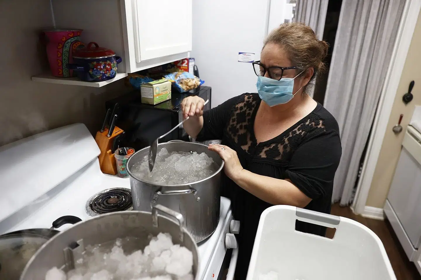 Marie Maybu smelter sne på sit komfur i Austin, Texas. Hun skal bruge vandet til at skylle ud i toilettet, fordi vandværkerne ikke fungerer.