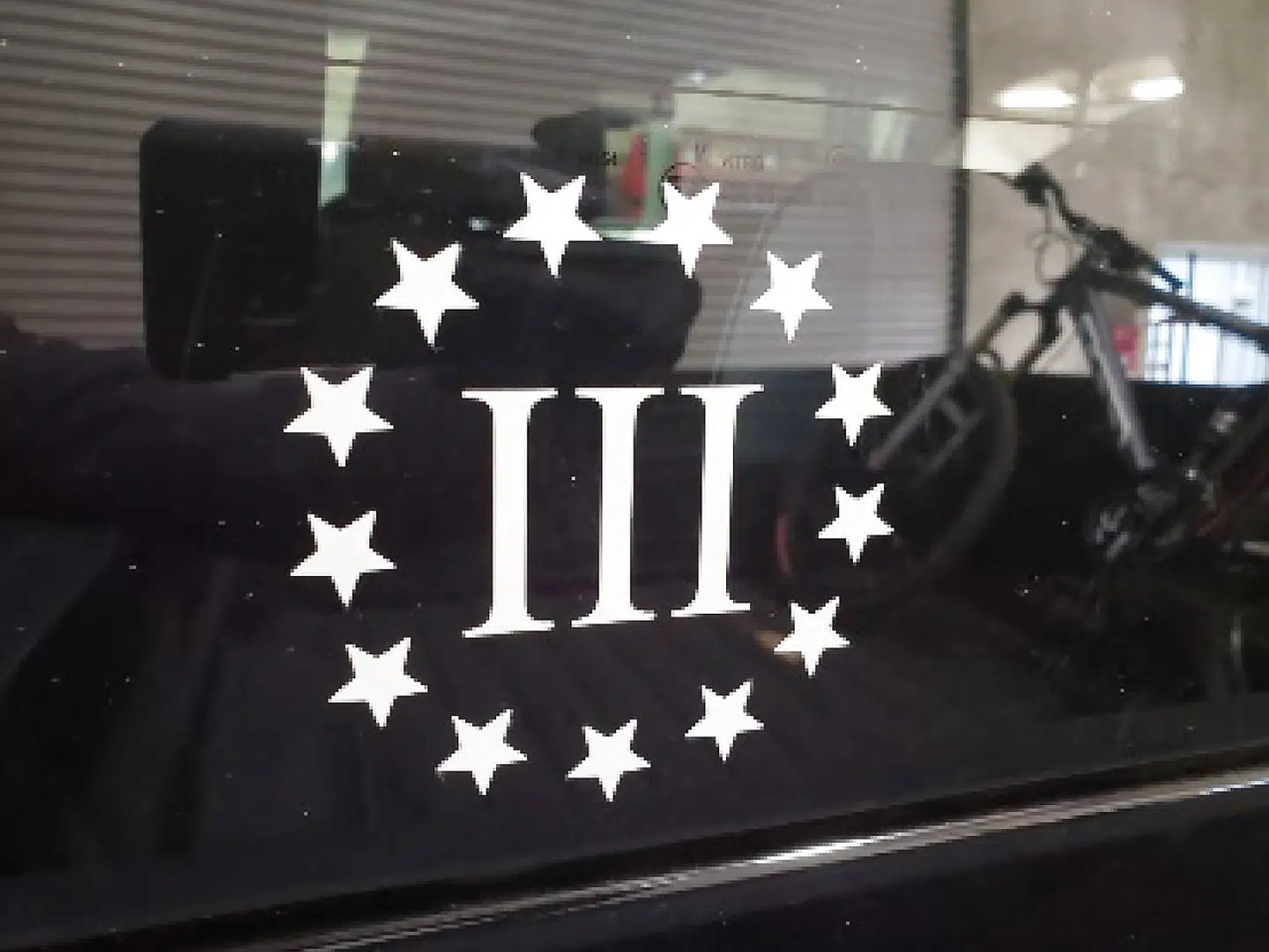 Et klistermærke med logoet fra organisationen 'Thre-Percenters' på Ian Benjamin Rogers bil. Organisationen er imod den siddende amerikanske regering.