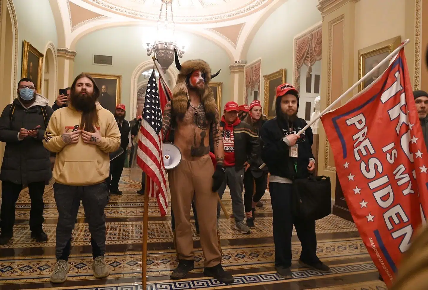 (FILES) In this file photo from on January 6, 2021, supporters of US President Donald Trump, including member of the QAnon conspiracy group Jake Angeli, aka Yellowstone Wolf (C), enter the US Capitol, in Washington, DC. - The American far right is angry: Angry at Joe Biden, angry at Donald Trump, angry at the enigmatic "Q" and angry with themselves. The online postings and chatrooms of extremists have been brimming with disappointment and dissent since the failed January 6 insurrection against Congress and the inauguration of Joe Biden as president. Followers of the QAnon conspiracy movement - - and its Delphic prophet Q - - are most in disarray, their millenarian predictions of chaos and doom accompanying Biden's elevation to the presidency not (or not yet) coming true. Ultranationalists like the Proud Boys, armed militias such as the Oath Keepers, and dangerous white supremacists and neo-Nazis have been pushed further underground, with followers who took part in the Capitol attack being swept up by law enforcement. (Photo by Saul LOEB / AFP)