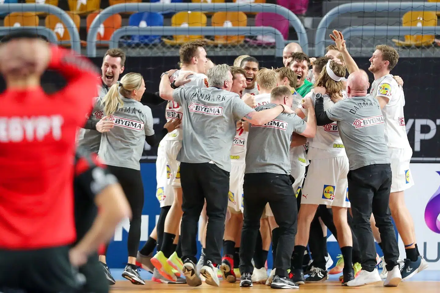 Denmark's players celebrate their win in the 2021 World Men's Handball Championship quarterfinal match between Denmark and Egypt at the Cairo Stadium Sports Hall in the Egyptian capital on January 27, 2021. (Photo by MOHAMED ABD EL GHANY / POOL / AFP)
