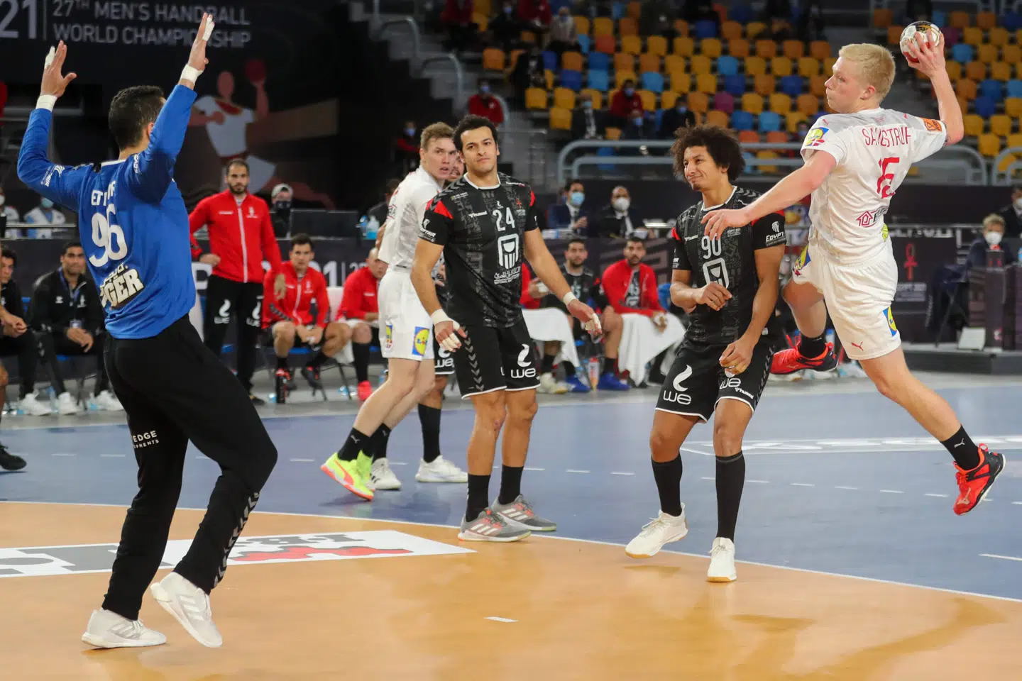 Denmark's pivot Magnus Saugstrup (R) attempts to score past Egypt's goalkeeper Mohamed Eltayar (L) during the 2021 World Men's Handball Championship quarterfinal match between Denmark and Egypt at the Cairo Stadium Sports Hall in the Egyptian capital on January 27, 2021. (Photo by MOHAMED ABD EL GHANY / POOL / AFP)