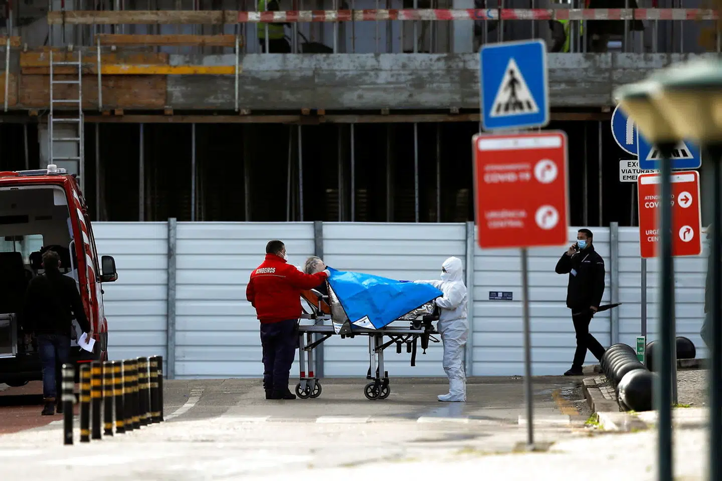 Man kører patienter ind på hospitalet fra ambulancer på gaden i Lisabon.