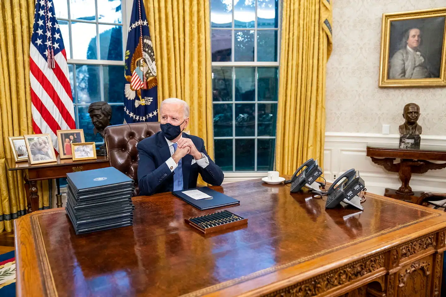 Joe Biden med billedet af Benjamin Franklin til højre.