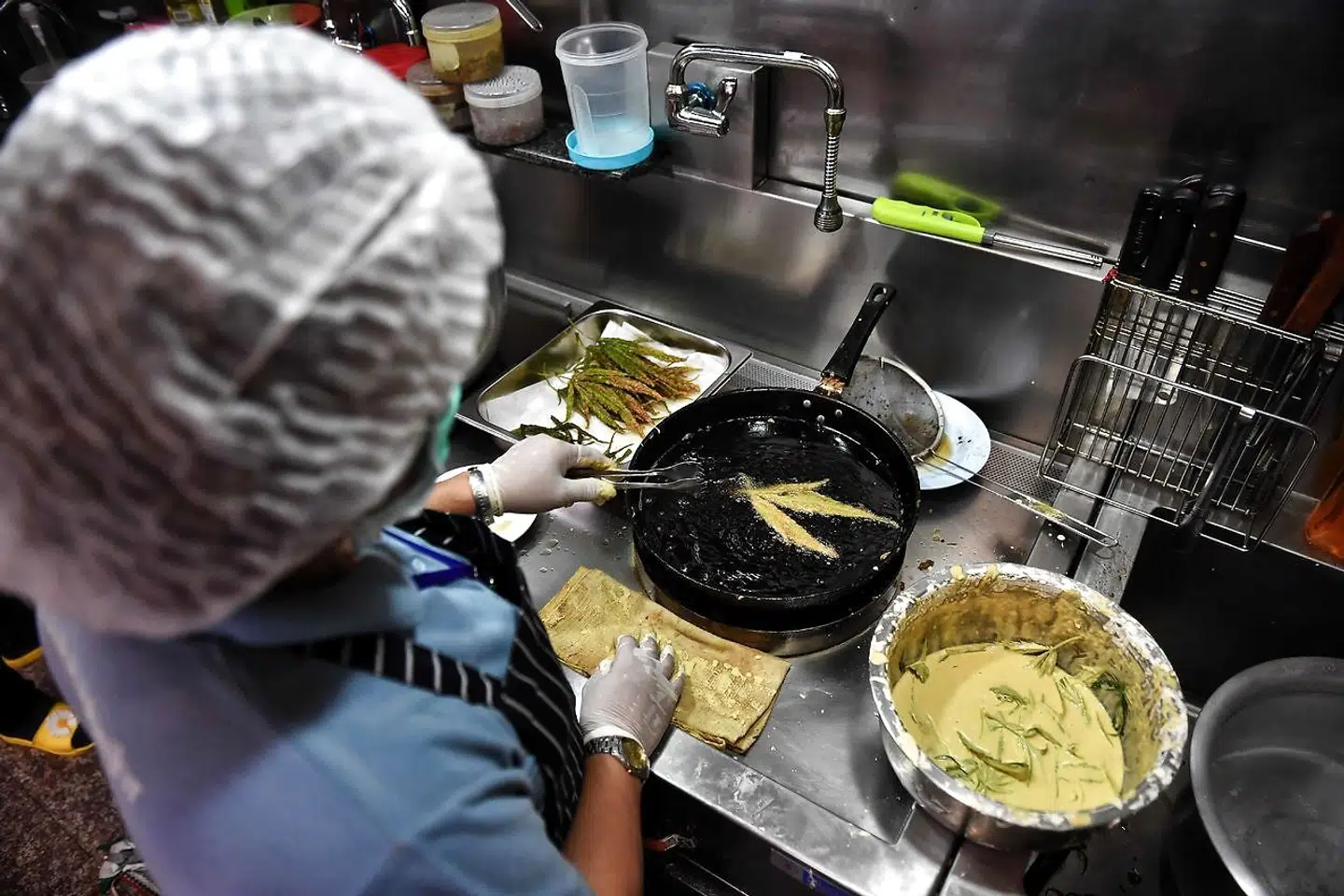 Friske kannabisblade bliver karamelliseret i køkkenet på Abhaibhubejhr Spa Cuisine i Thailand.