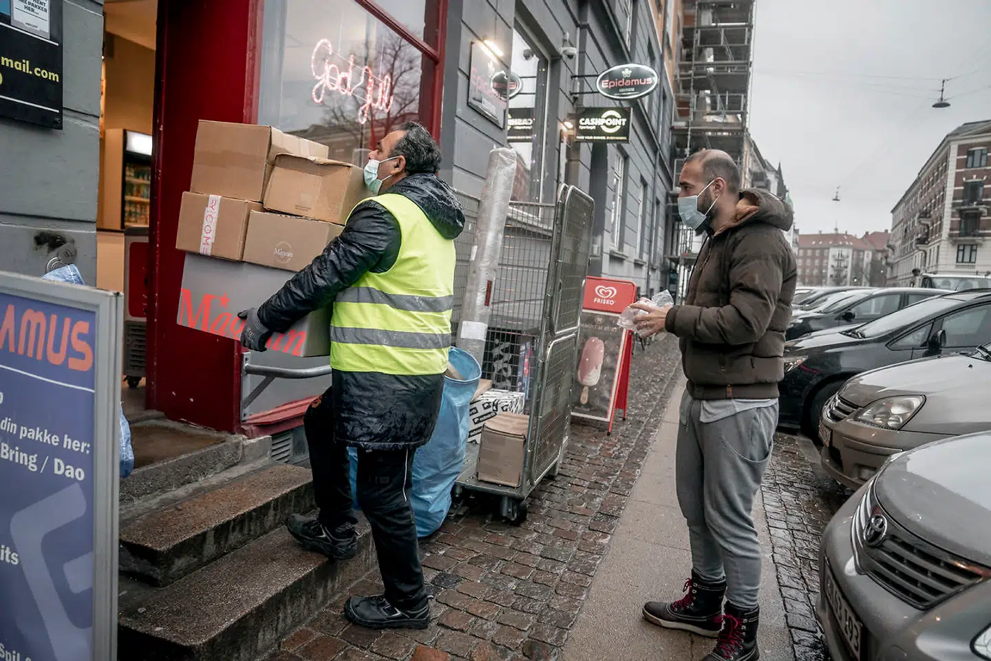 Her står folk i kø til en pakkeshop med mundbind på. Måske kan det snart blive et krav med mundbind i det offentlige rum.
