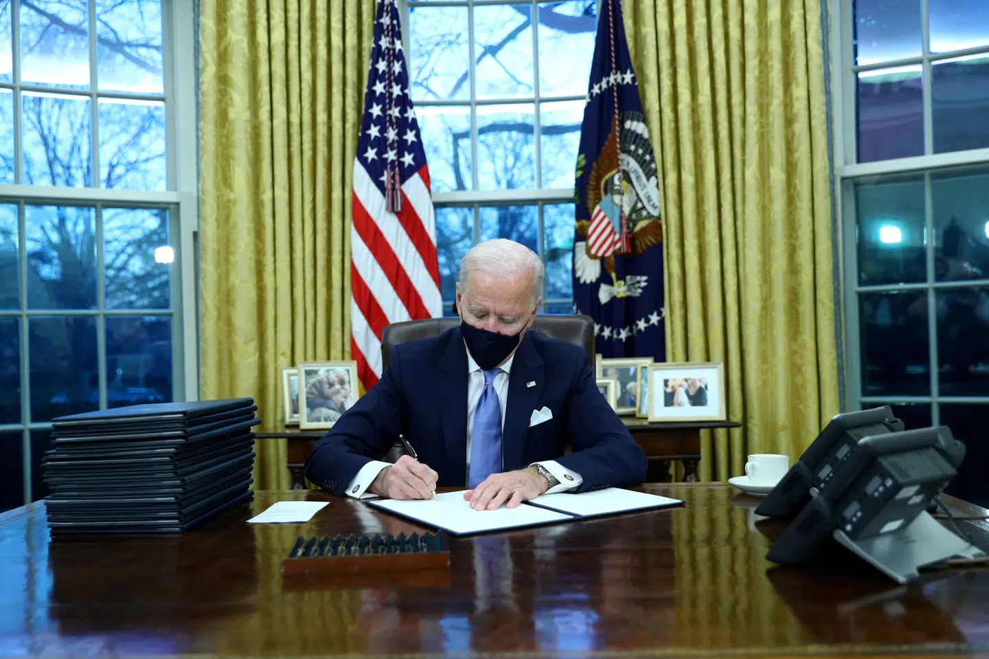 Joe Biden spildte ingen tid på sin første dag som præsident, hvor han underskrev en lang række dekreter i Det Ovale Værelse. Tom Brenner/Reuters