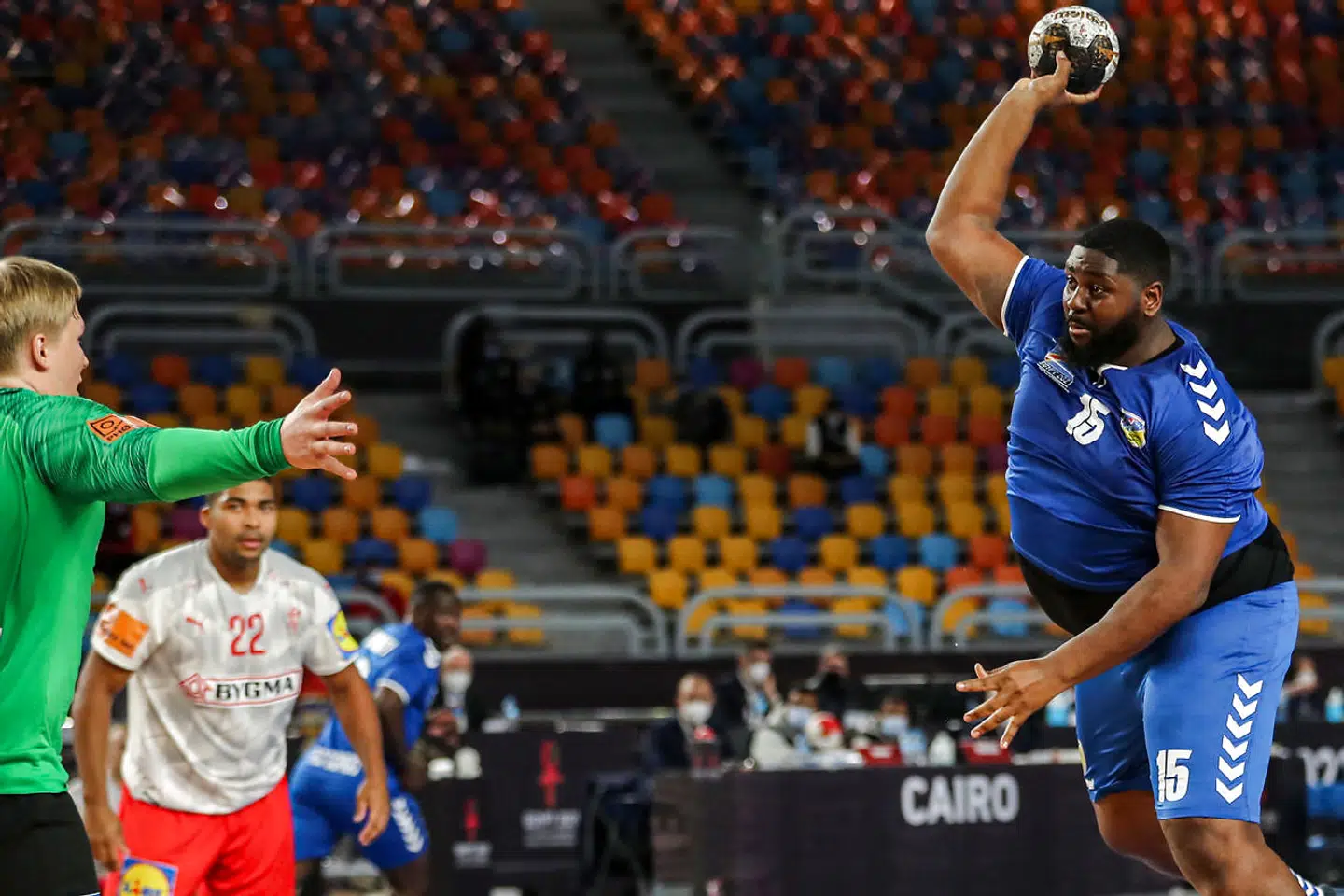 Democratic Republic of Congo's pivot Gauthier Mvumbi (R) attempts a shot during the 2021 World Men's Handball Championship match between Group D teams DR Congo and Denmark at the Cairo Stadium Sports Hall in the Egyptian capital on January 17, 2021. (Photo by MOHAMED ABD EL GHANY / POOL / AFP)