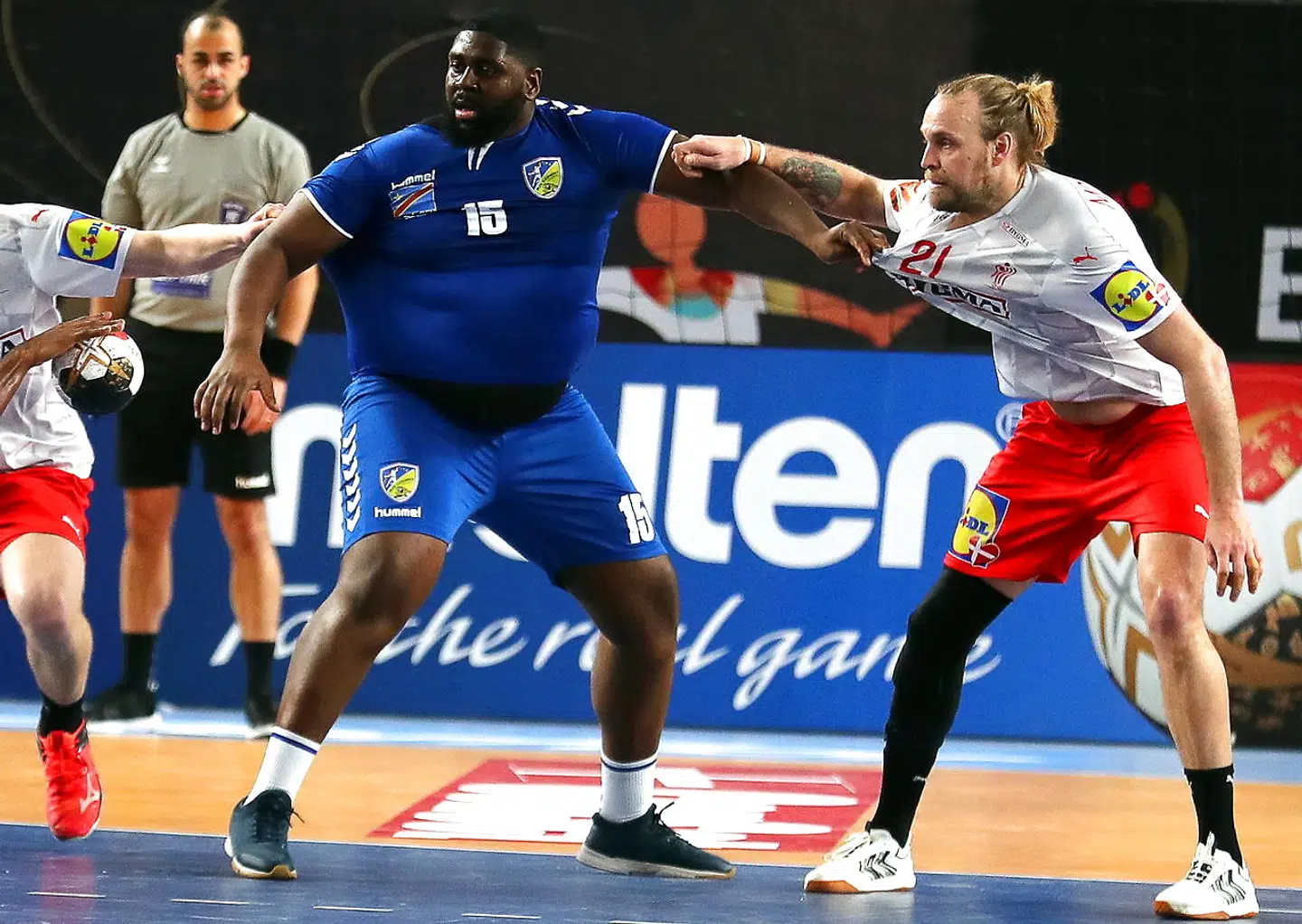 epa08944689 Gauthier Mvumbi Thierry (L) of DR Congo in action against Henrik Mollgaard Jensen (R) of Denmark during the match between DR Congo and Denmark at the 27th Men's Handball World Championship in Cairo, Egypt, 17 January 2021. EPA/Mohamed Abd El Ghany / POOL