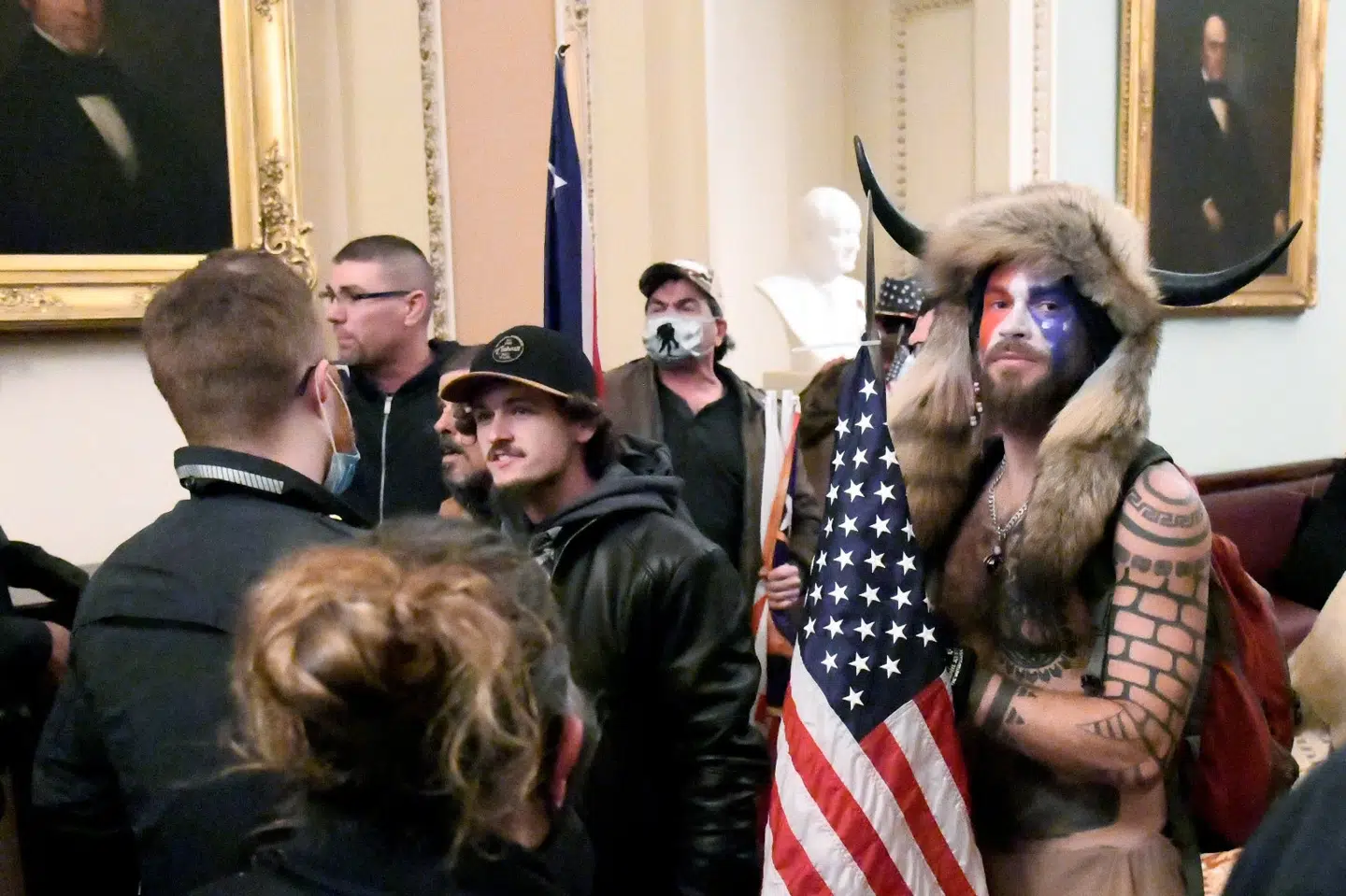Jacob Chansley, der også er kendt under navnet Jake Angeli eller QAnon-shamanen, ses her i bar overkrop, pelshue og et spyd med det amerikanske flag. Han fremstilles senere fredag for en dommer. Mike Theiler/Reuters