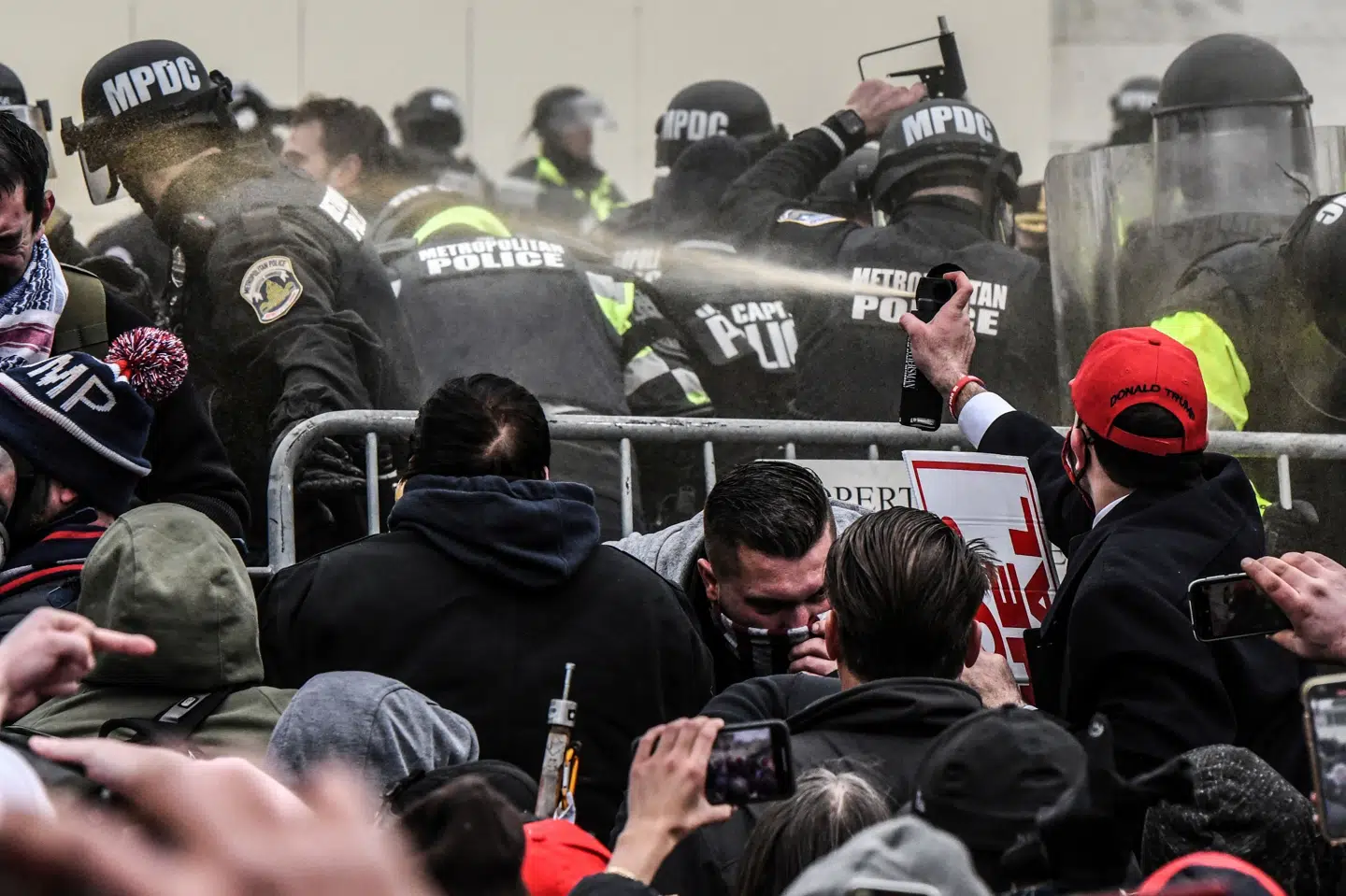 En tilhænger af præsident Donald Trump sprøjter peberspray mod politiet i forbindelse med angrebet mod Kongressen onsdag. (Arkivfoto) Stephanie Keith/Reuters
