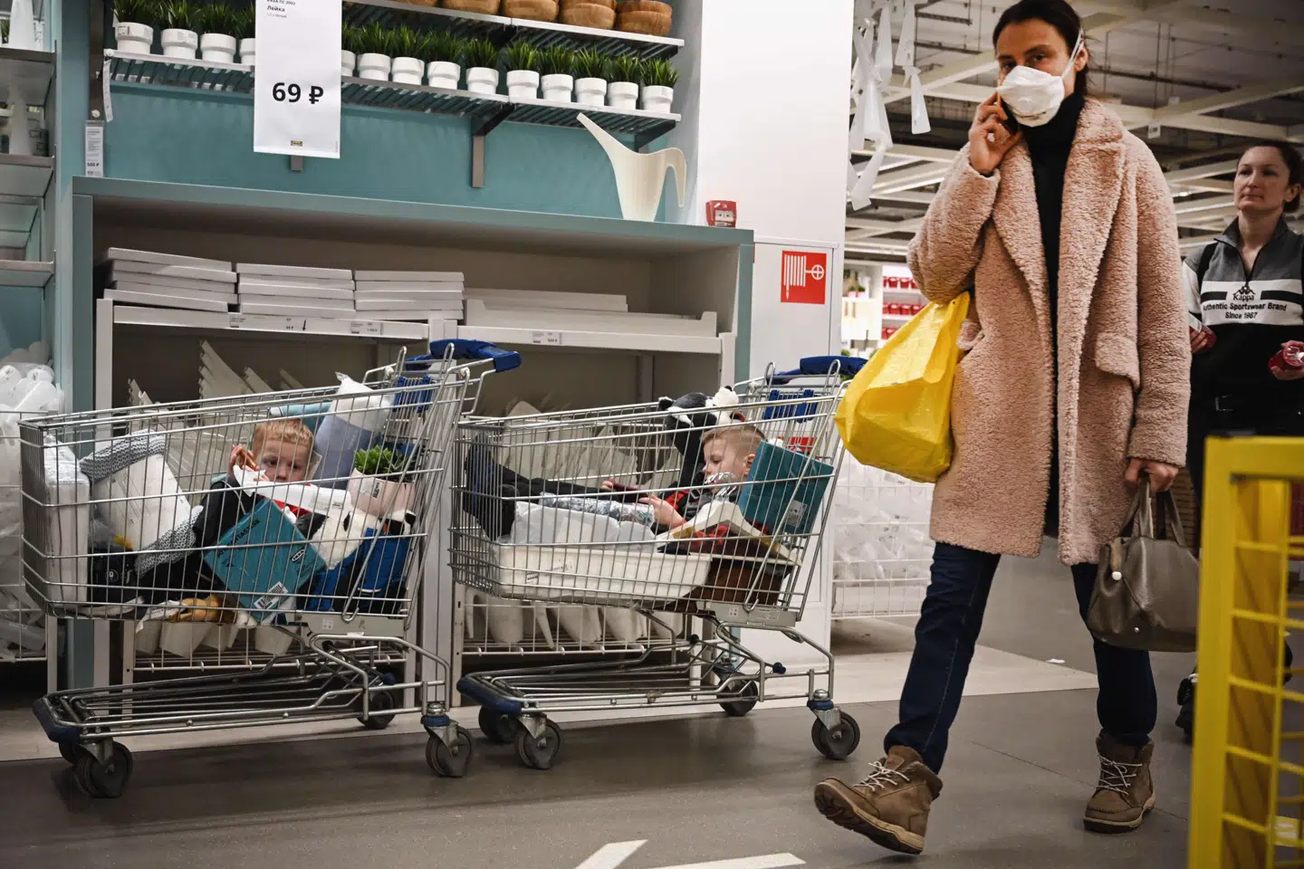 To børn sidder i indkøbsvognene, mens deres forældre køber ind i en butik i Moskva. Nye tal tyder på, at Rusland har over tre gange så mange dødsfald blandt personer med covid-19, som de officielle opgørelser viser.