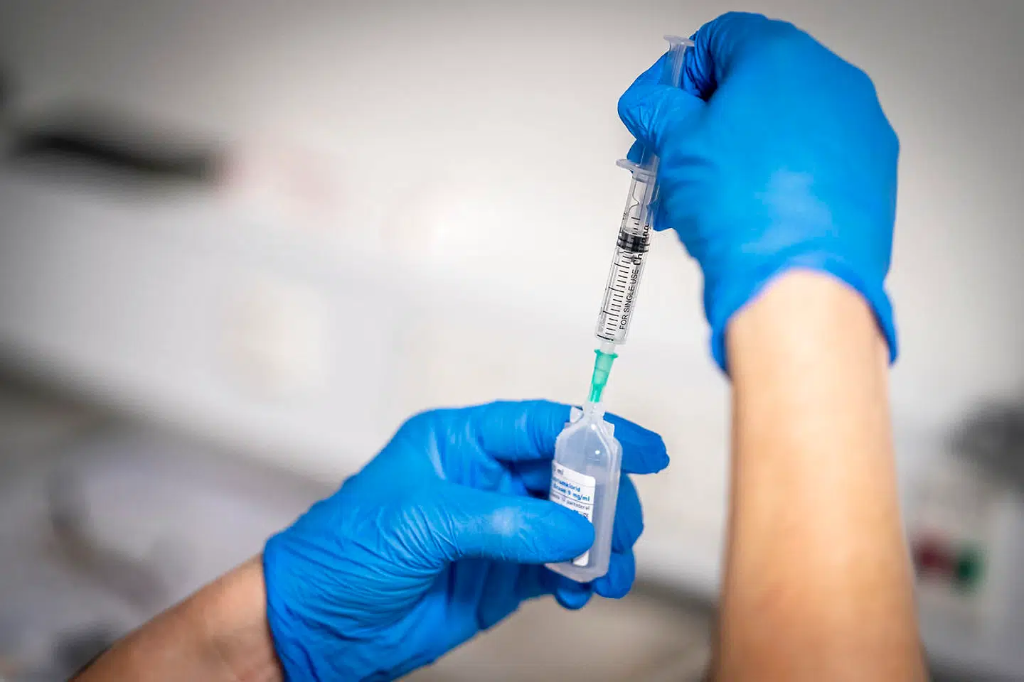 Vaccinen bliver blandet umiddelbart inden brug af sundhedspersonale på stedet. Her er det vacciner sendt ud fra Sjællands Universitetshospital i Roskilde, der bliver gjort klar søndag morgen. Vaccinationer blev givet stort set samtidig i alle landets fem regioner.