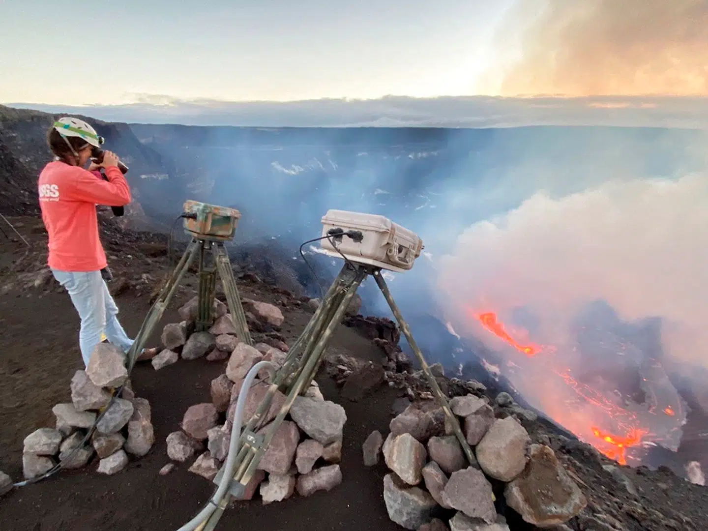 På dette foto fra det amerikanske geologiske overvågningscenter (USGS) ses en videnskabsmand, der måler det nyeste udbrud af vulkanen Kilauea i Hawaii 21. december 2020.