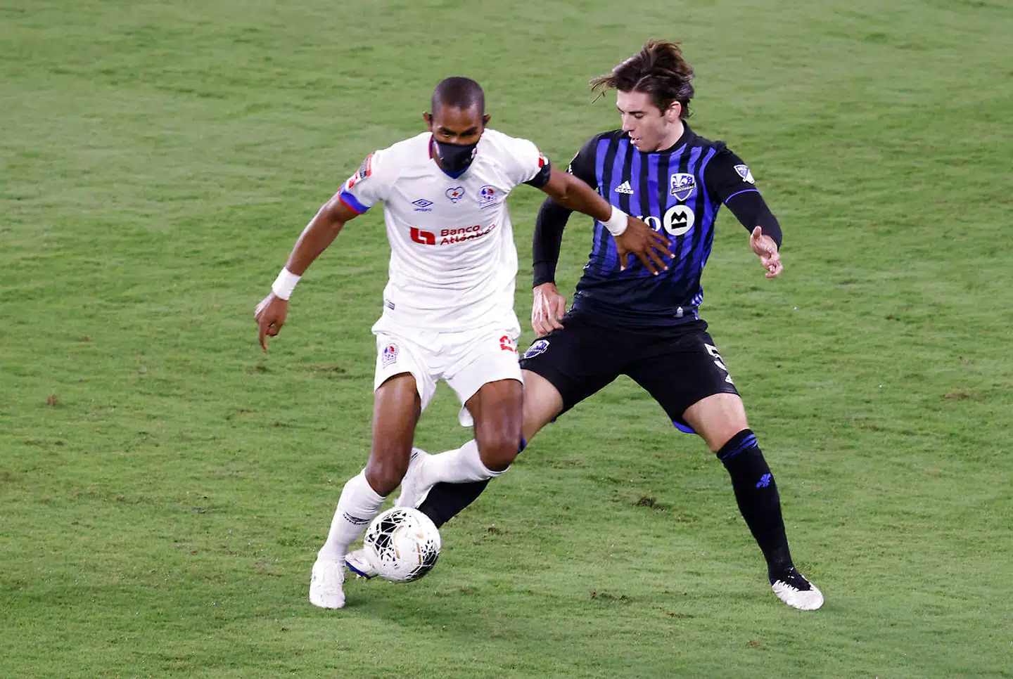 Dec 15, 2020; Orlando, Florida, USA; Olimpia forward Jerry Bengtson (left) and Montreal Impact defender Luis Binks (right) battle for the ball during the first half of the 2020SCCL quarterfinal match at Exploria Stadium. Mandatory Credit: Reinhold Matay-USA TODAY Sports