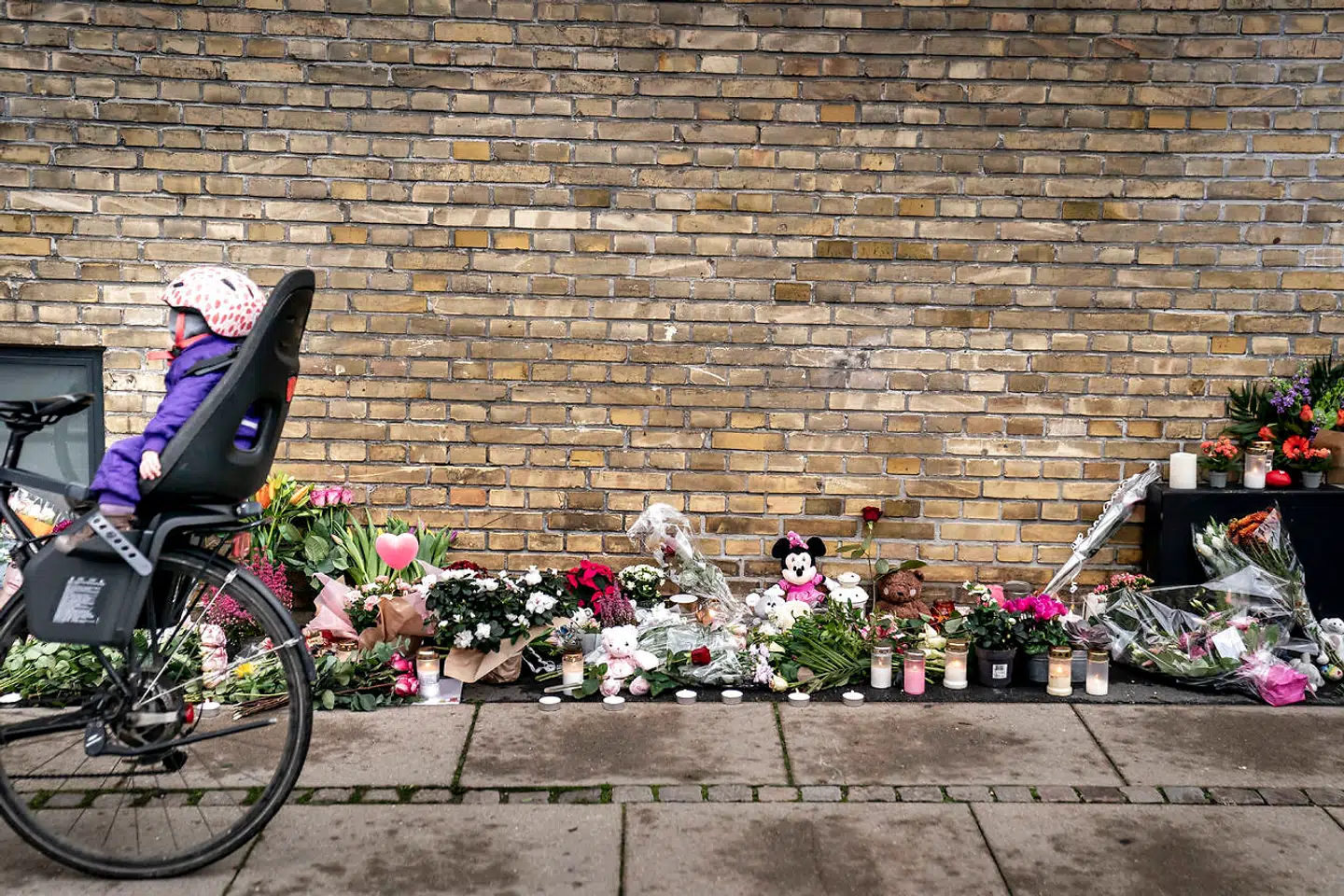 Folk lægger blomster og mindes den femårige pige, der mistede livet efter at være blevet ramt af en mandlig flugtbilist. Gerningsstedet bliver besøgt på Peter Bangs Vej i Valby 29. oktober 2020. (Foto: Mads Claus Rasmussen/Ritzau Scanpix)
