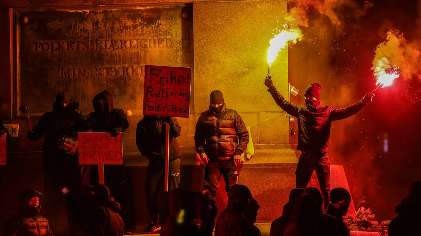 Med sig har gruppen flere skilte, der omhandler epidemiloven og corona-restriktionerne. Foto: Steven Knap/Byrd