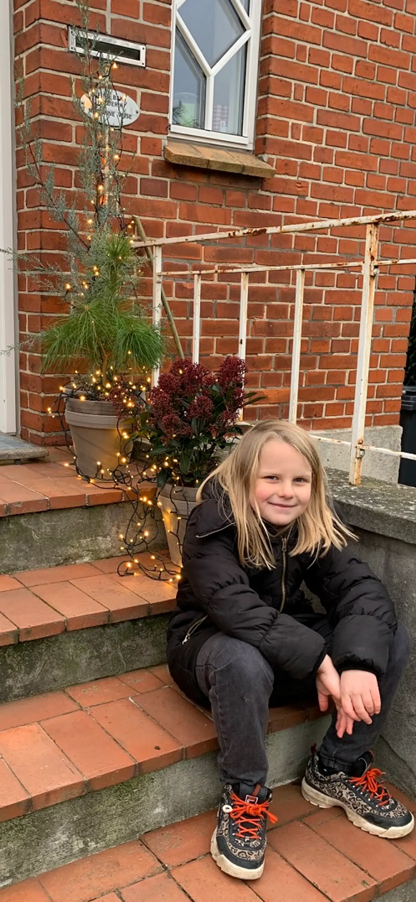 Marianne Thulstrup Veises barnebarn på trappen foran huset.