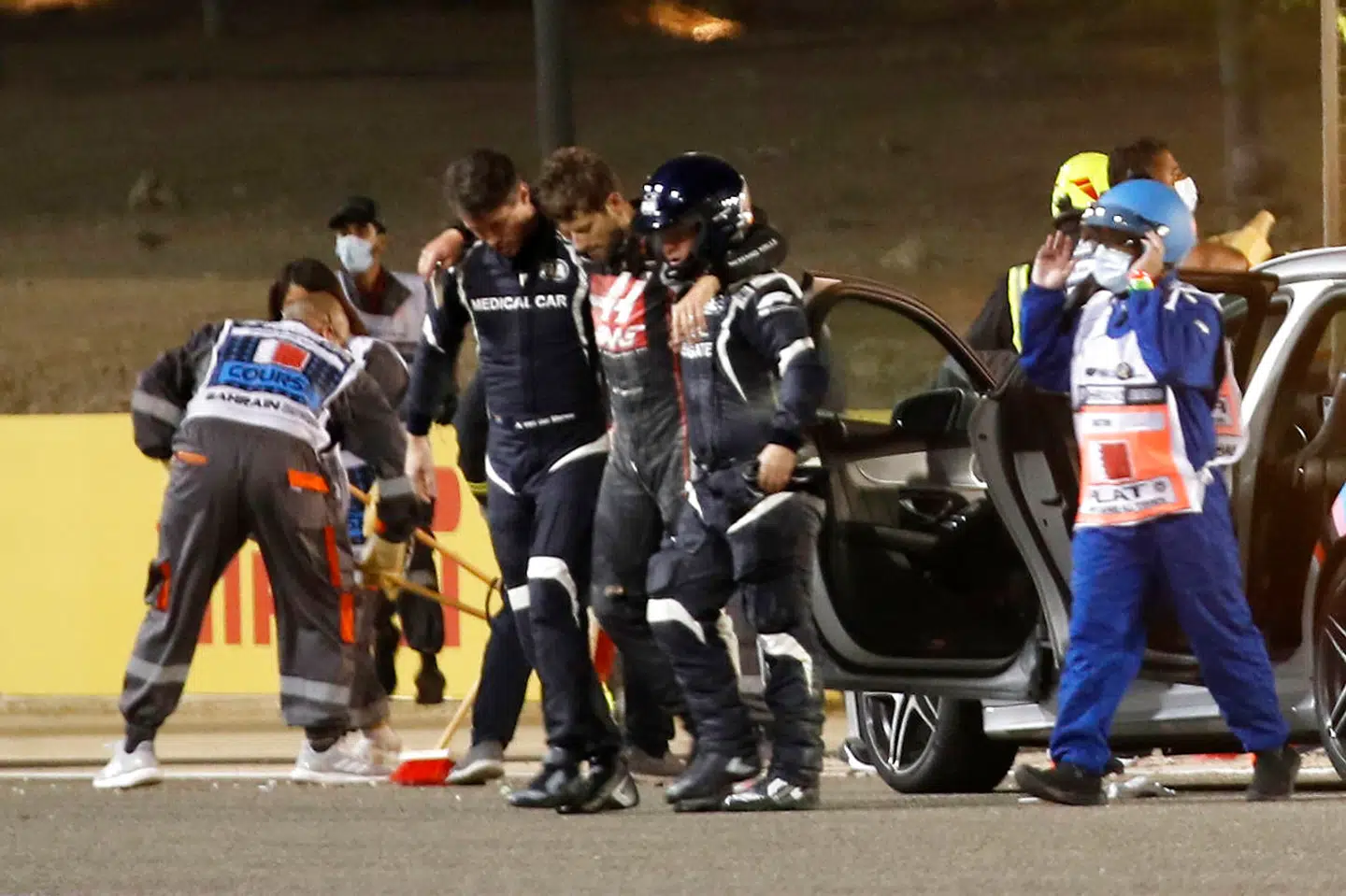 Romain Grosjean hjælpes væk fra sin brændende bil.