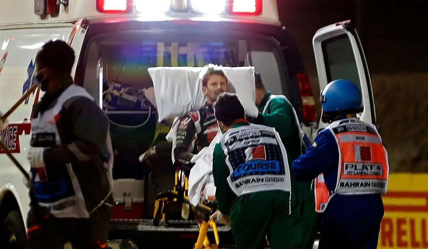 Romain Grosjean føres væk i ambulancen.
