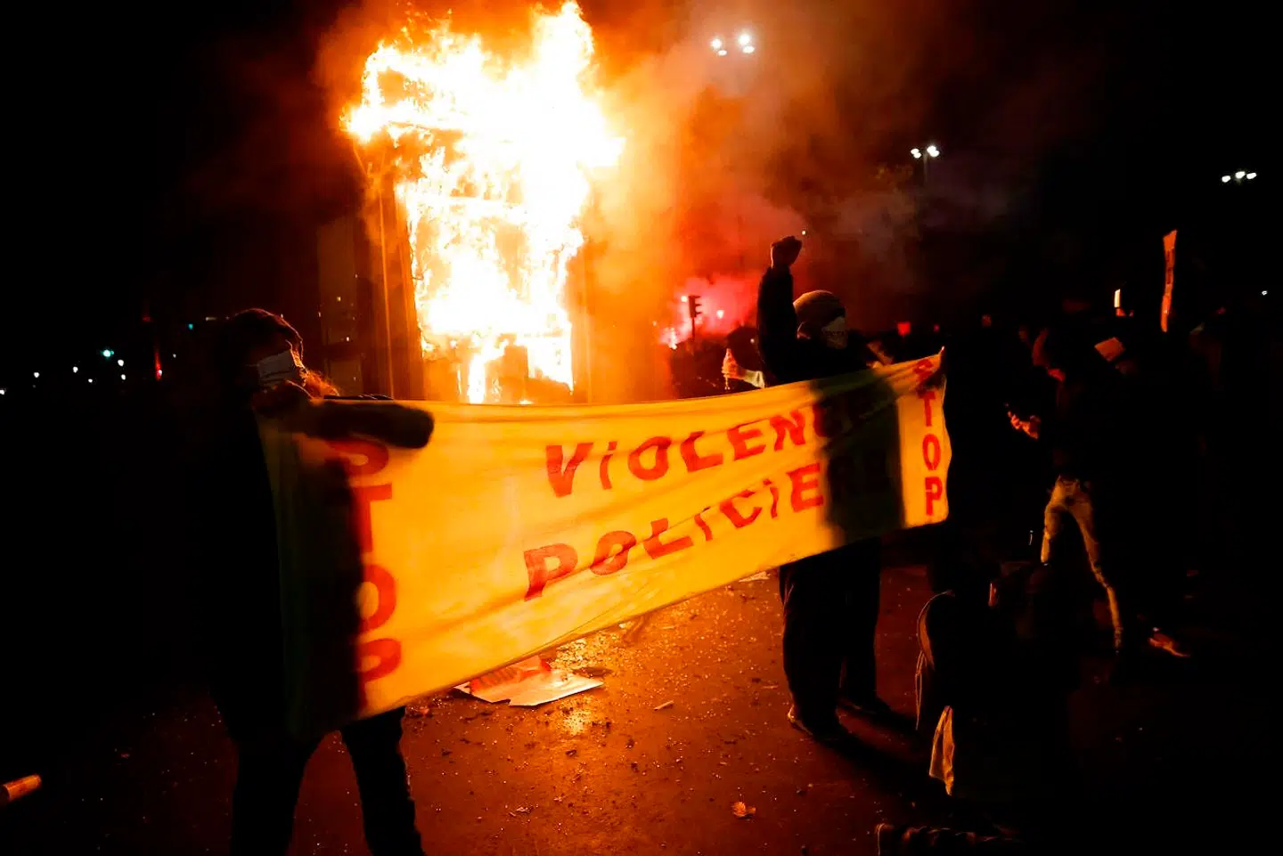 Demonstranter der holder et banner, hvor der står 'Voldeligt Politi'. Demonstranterne var på gaden for at protestere mod en ny fransk sikkerhedslov, der blandt andet skal forbyde filmoptagelser af politiet. (Photo by Thomas COEX / AFP)