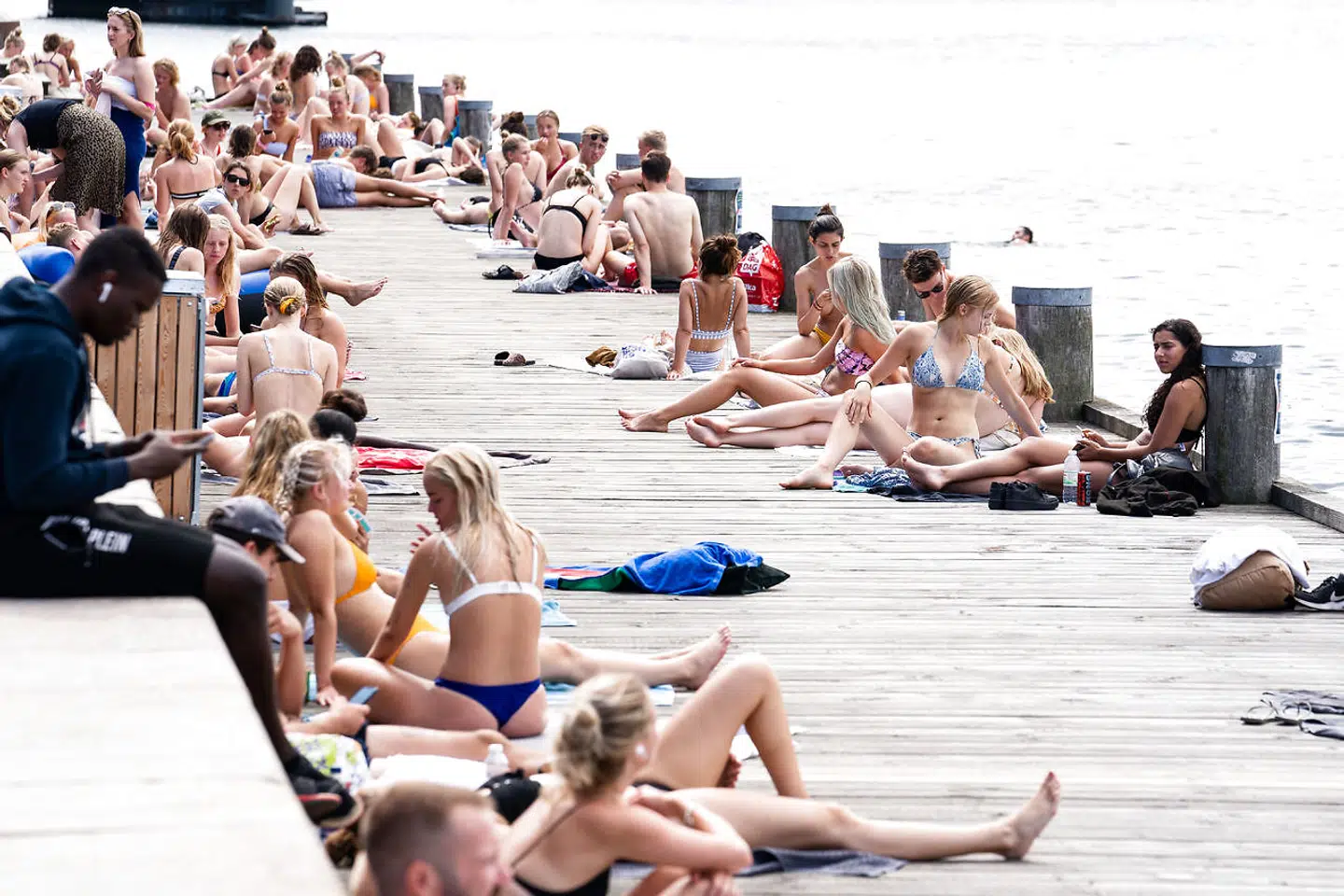 Mange unge samlet under solen på Islands Brygge i København, torsdag den 6. august 2020.