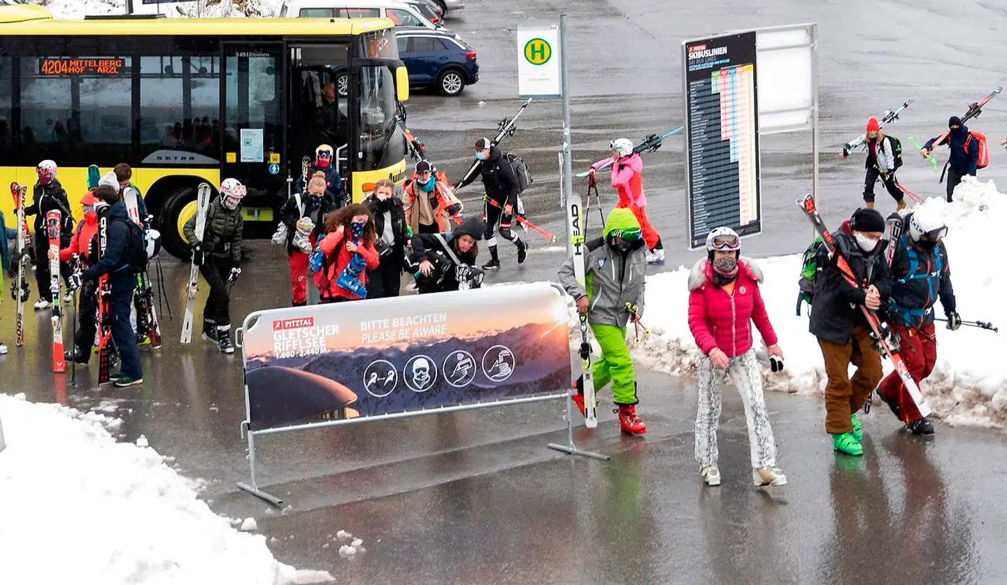 Skiløberne går forbi et skilt med coronaanvisningerne på vej mod gletsjeren Pitztal i Østrig den 29. oktober 2020.