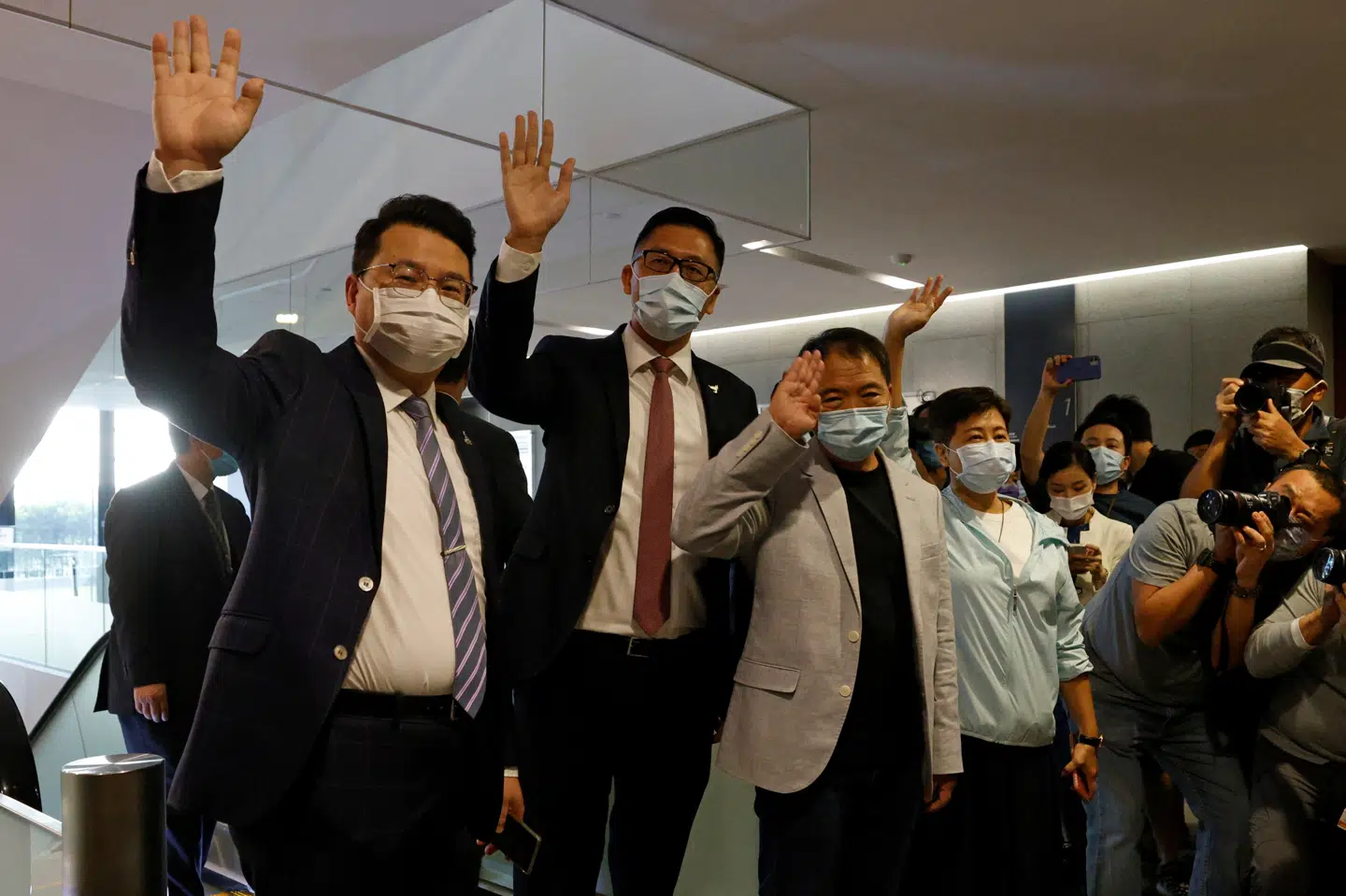 Fire prodemokratiske medlemmer af parlamentet vinker, efter at de har meddelt, at de trækker sig i solidaritet med udsmidte medlemmer. Tyrone Siu/Reuters
